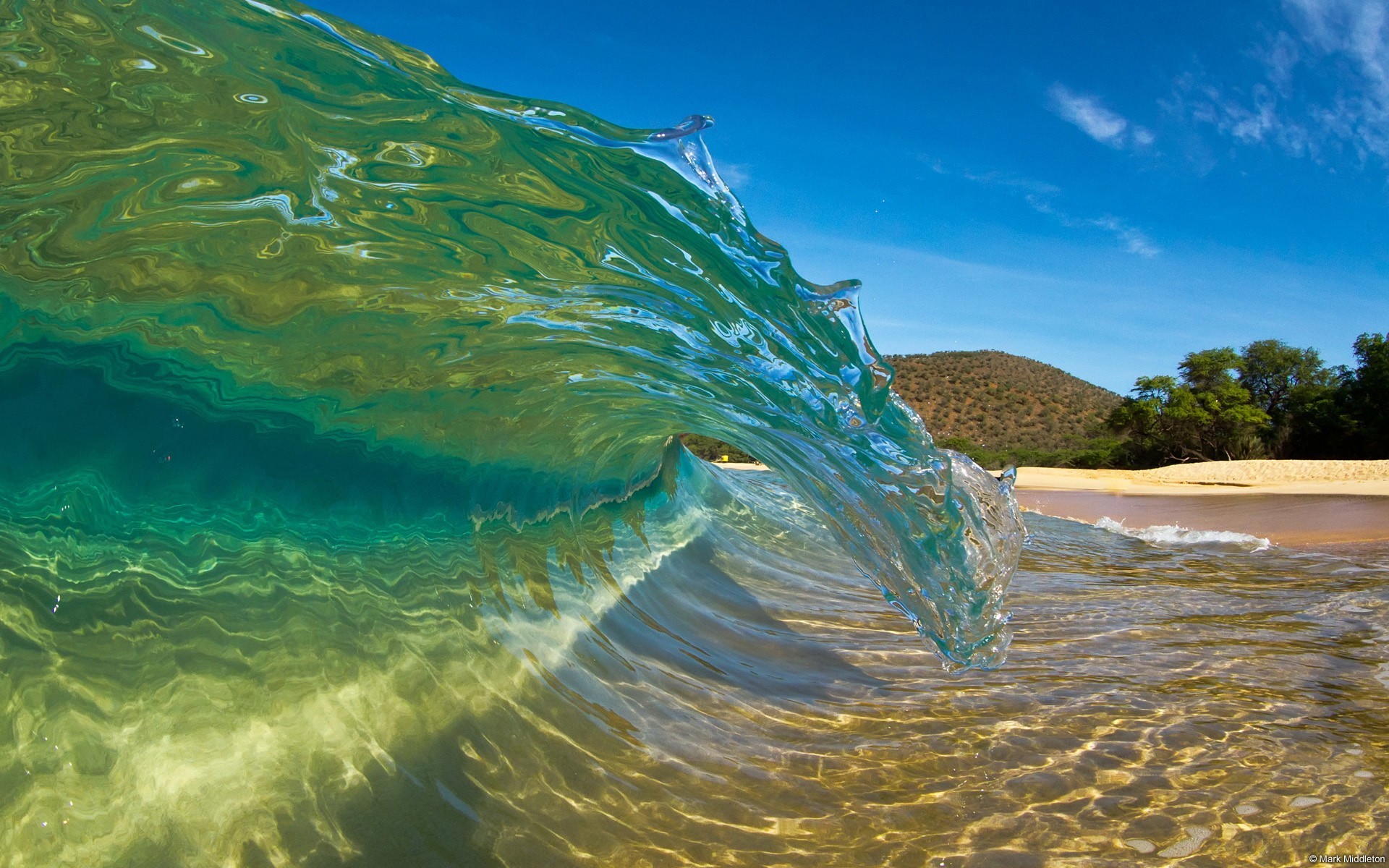 Transparent wave crashing on a sandy beach HD Wallpaper