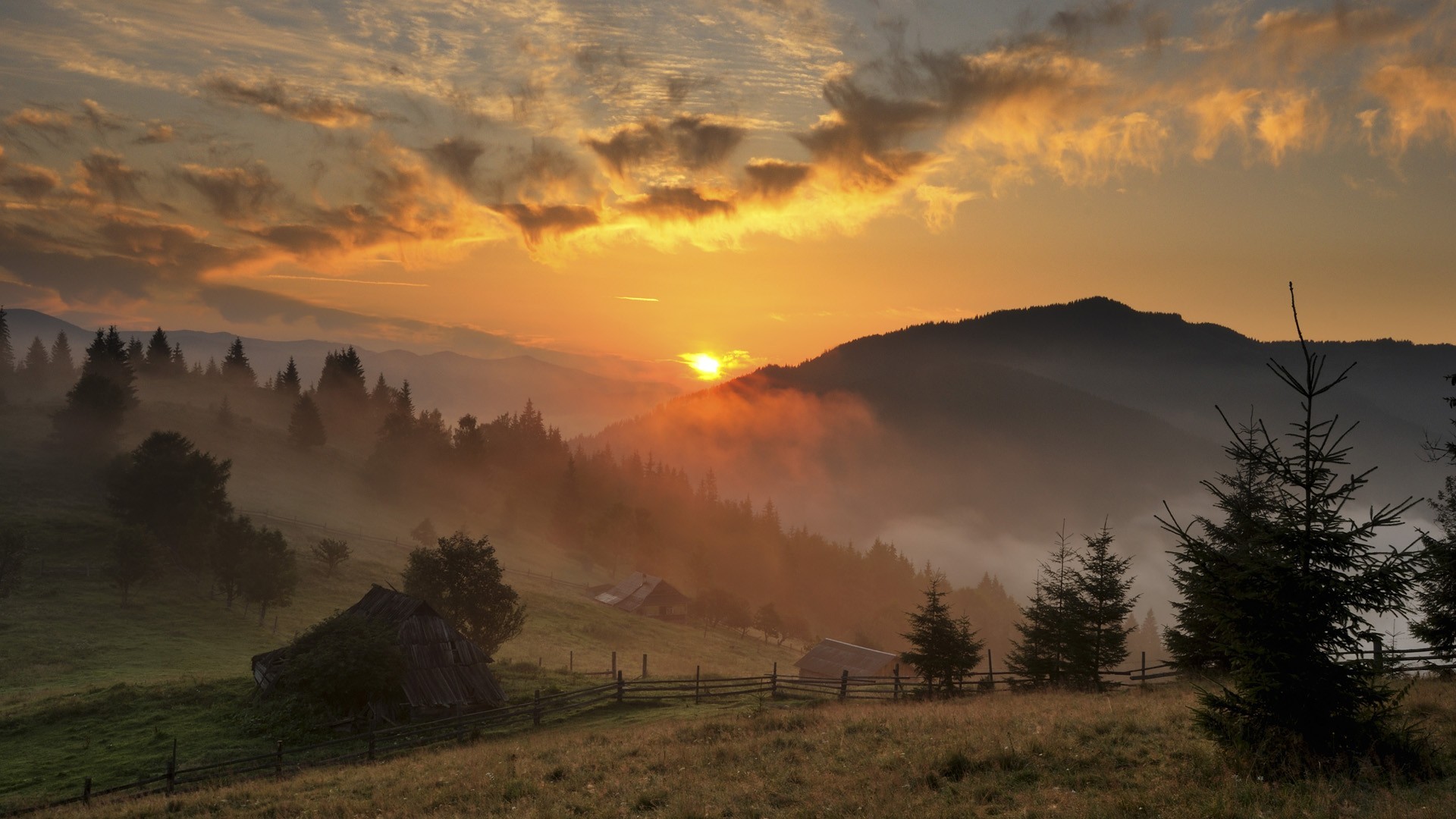Sunrise over misty mountains with traditional houses HD Wallpaper