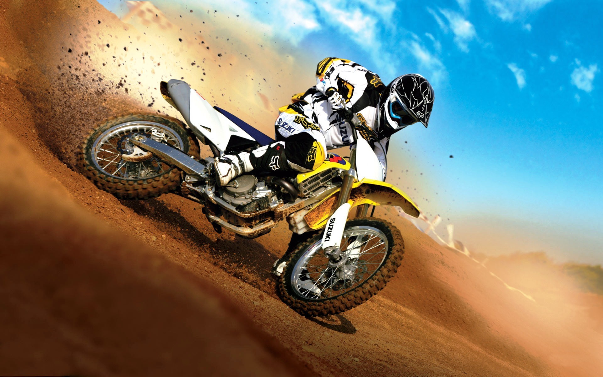 Suzuki motocross rider on a dirt track HD Wallpaper
