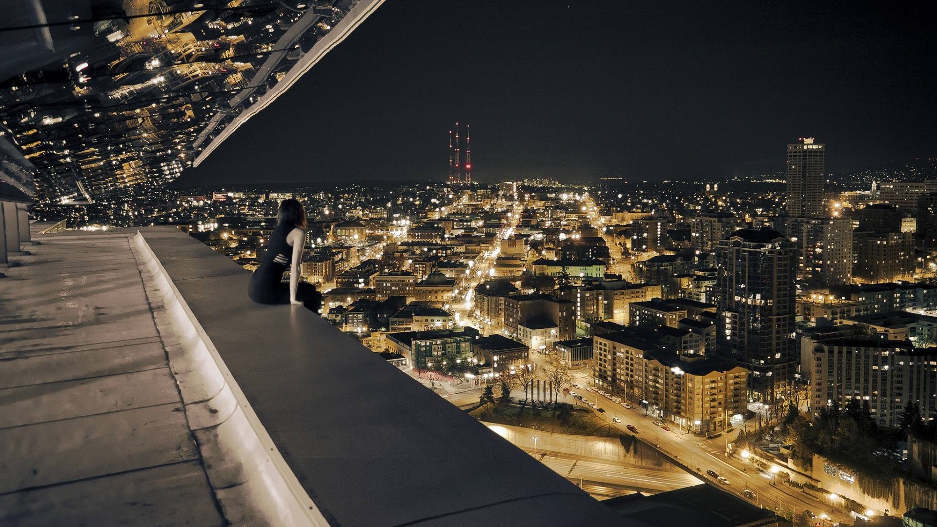 Woman on a rooftop overlooking a city at night HD Wallpaper