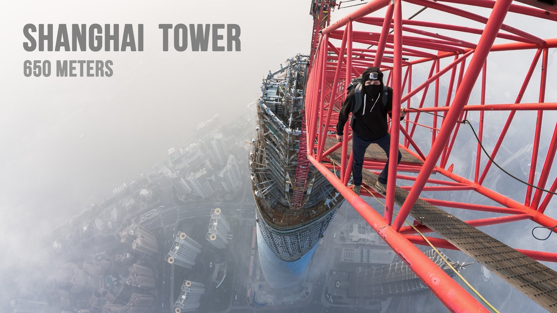Man climbing Shanghai Tower crane at 650 meters HD Wallpaper