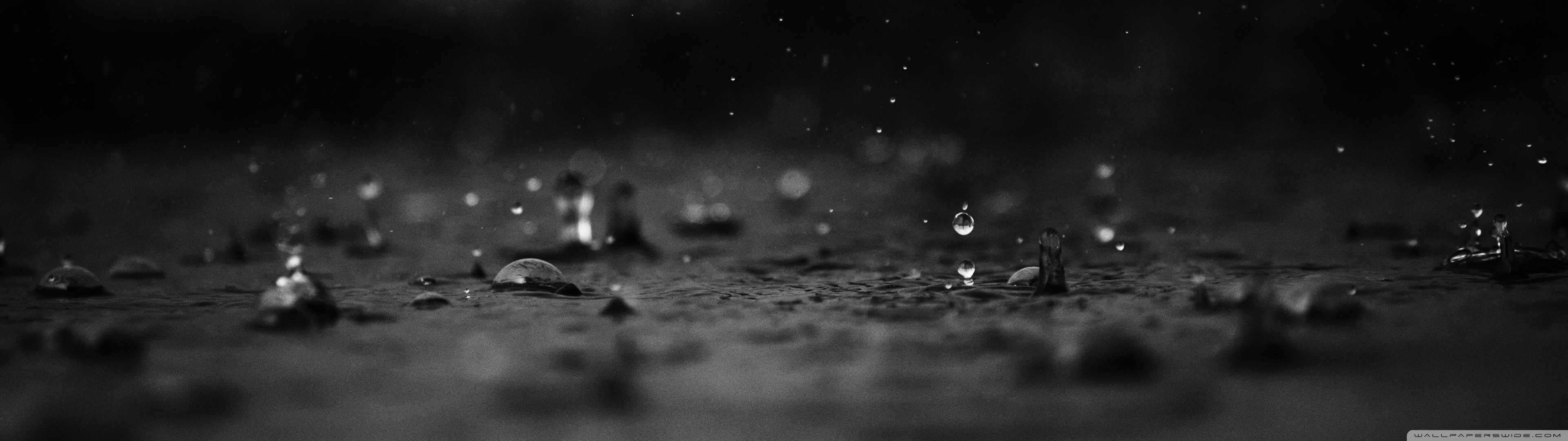 Monochrome water drops falling on a dark surface HD Wallpaper