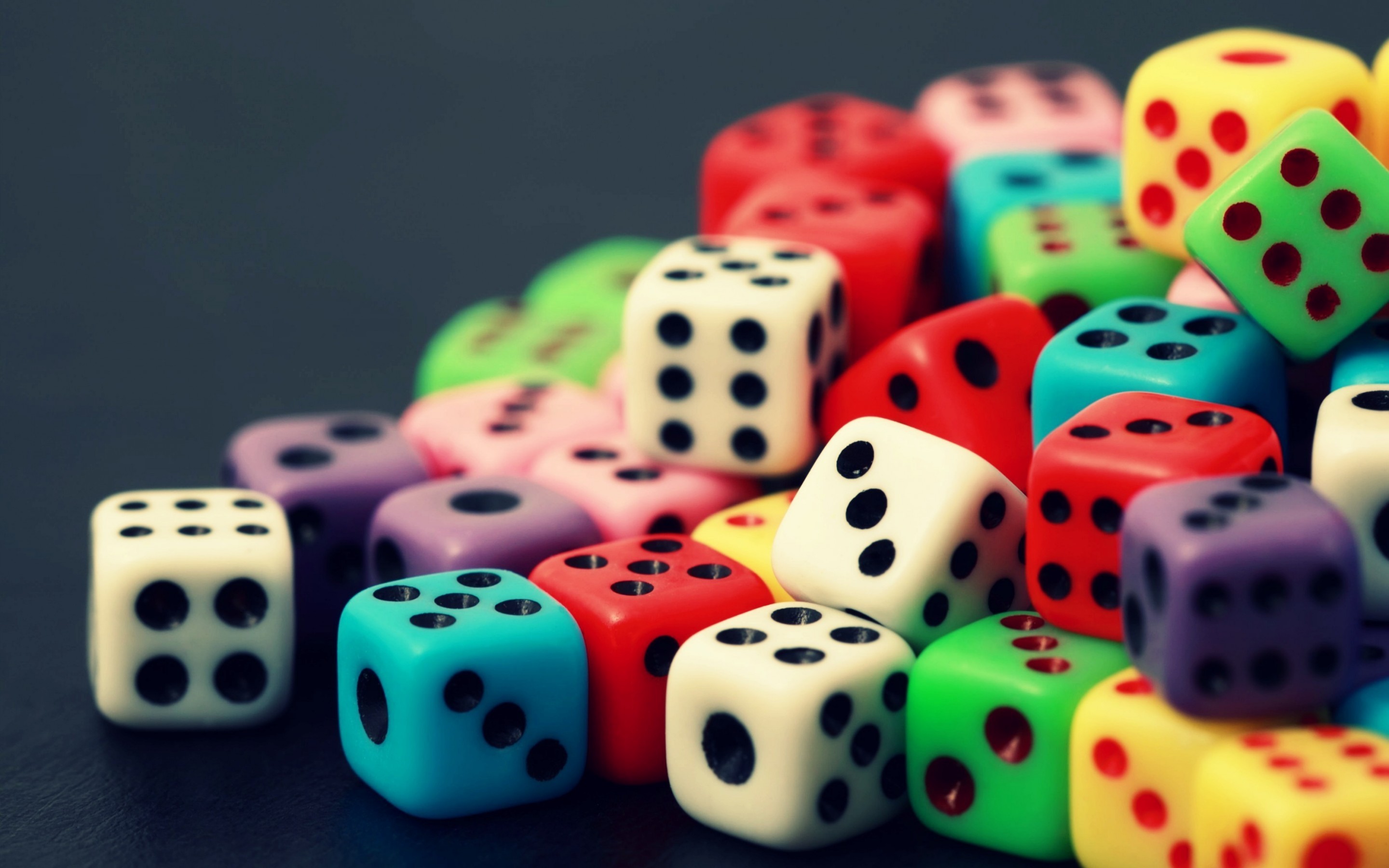 A pile of colorful dice on a dark surface HD Wallpaper
