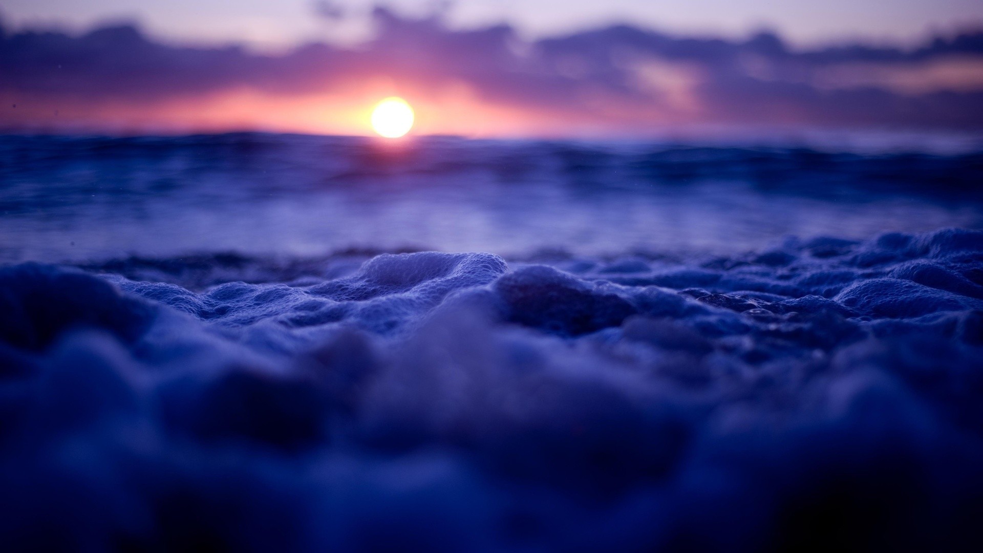 Sunset over the sea with foamy waves HD Wallpaper