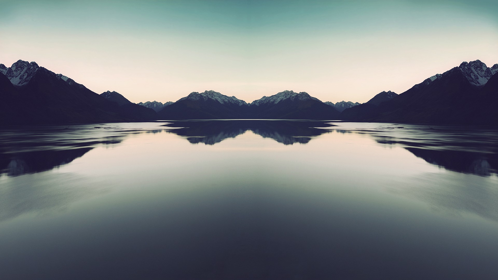 Symmetrical mountain reflection over a calm lake HD Wallpaper