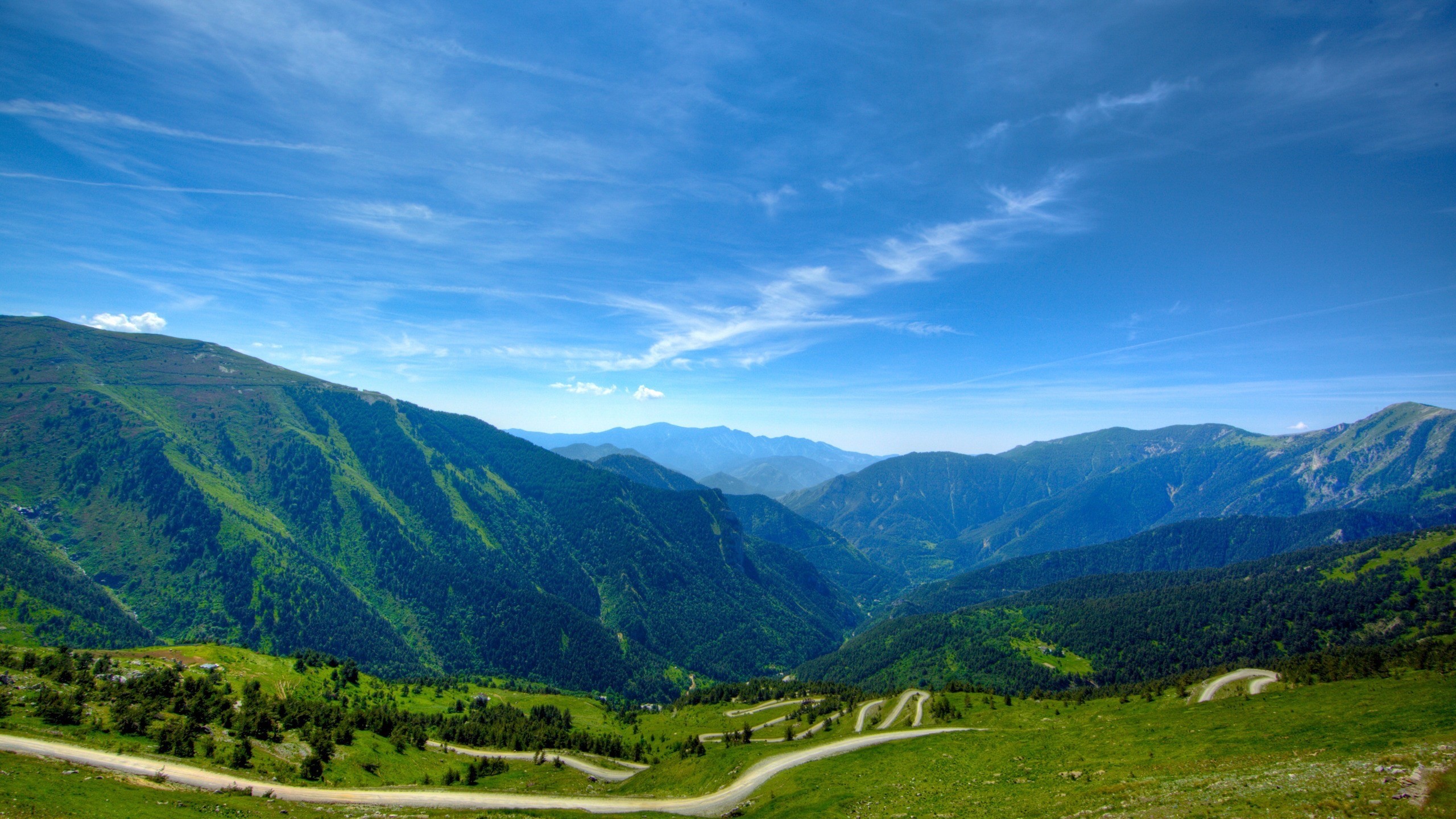 Mountain landscape with winding road and blue sky HD Wallpaper