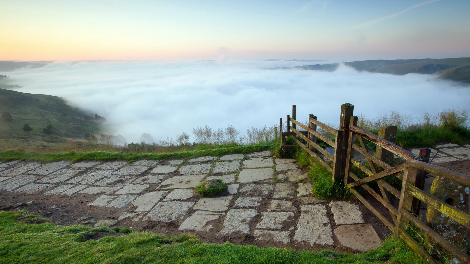 Foggy valley with stone path and wooden gate HD Wallpaper