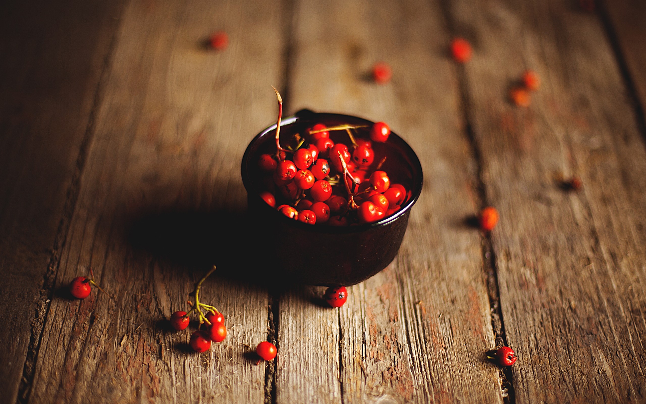 Red berries in a bowl on a wooden surface HD Wallpaper
