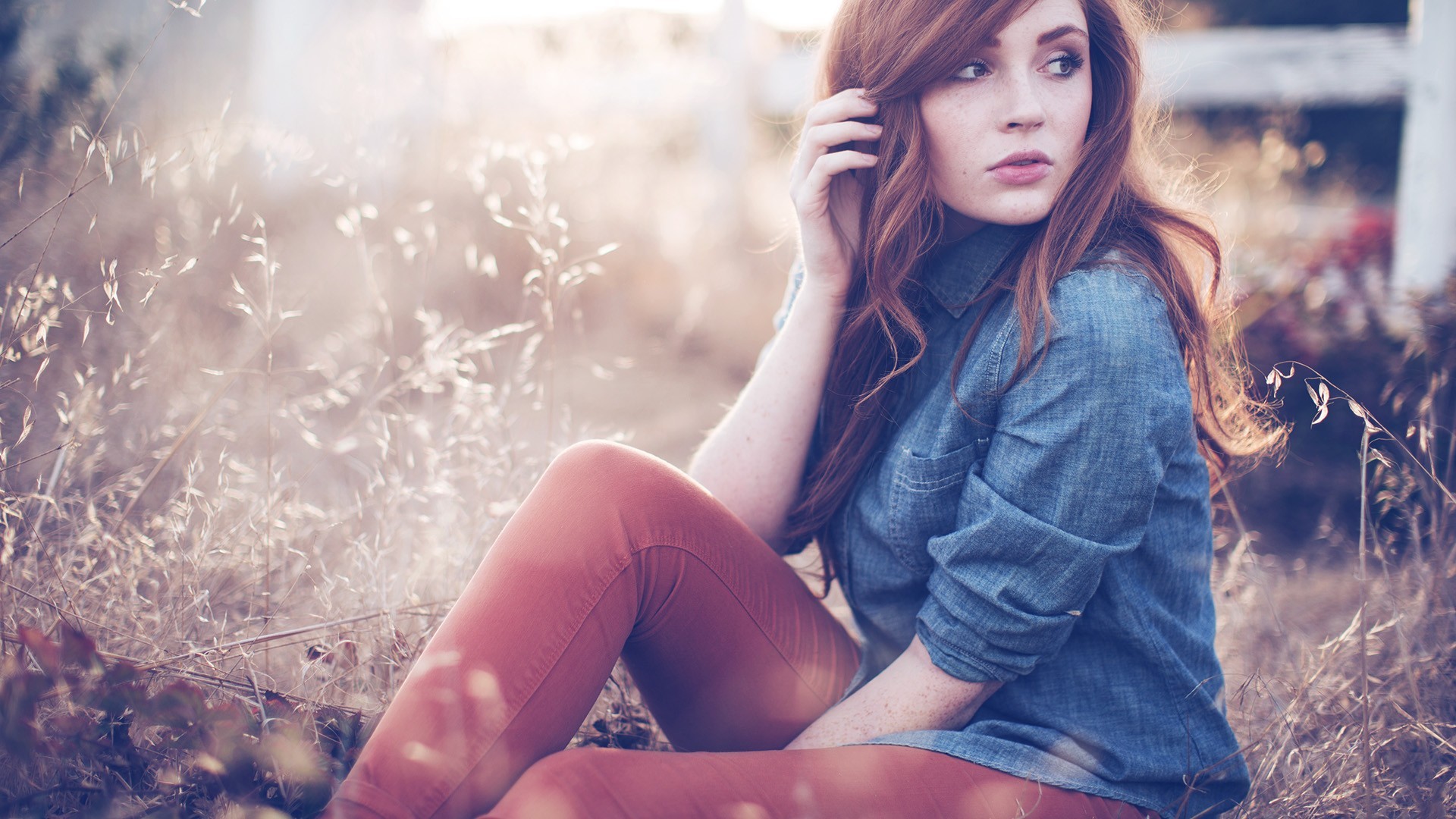 Woman with red hair sitting in dry grass HD Wallpaper