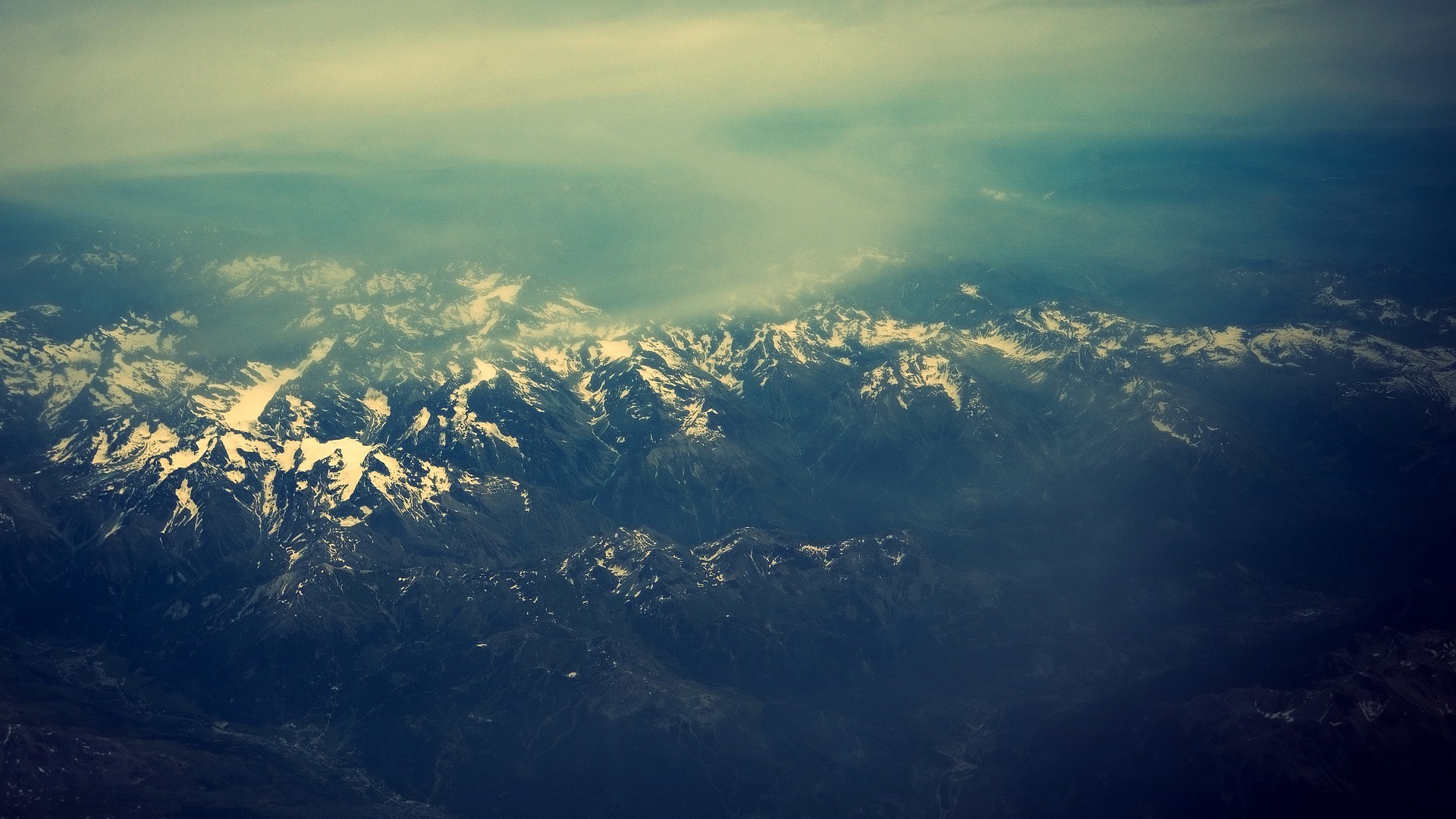Snow-capped mountains seen from above HD Wallpaper