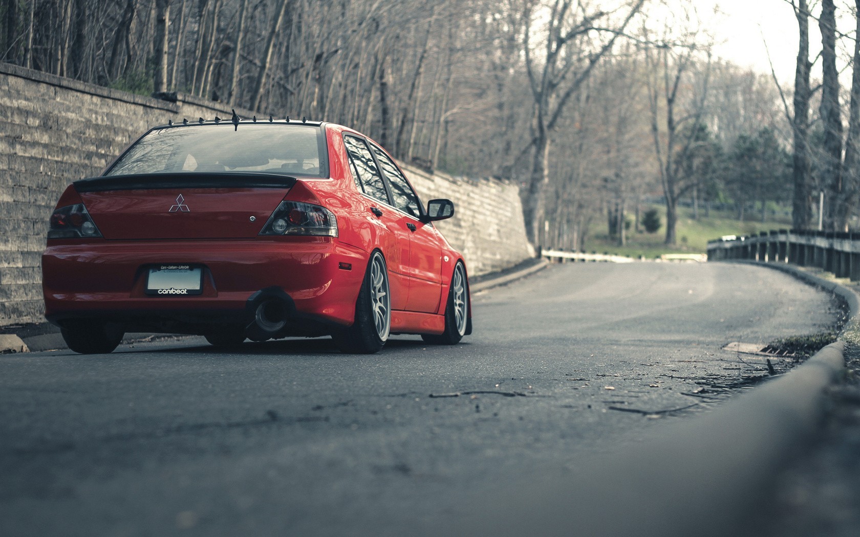 Red Mitsubishi Lancer Evolution parked on a road HD Wallpaper