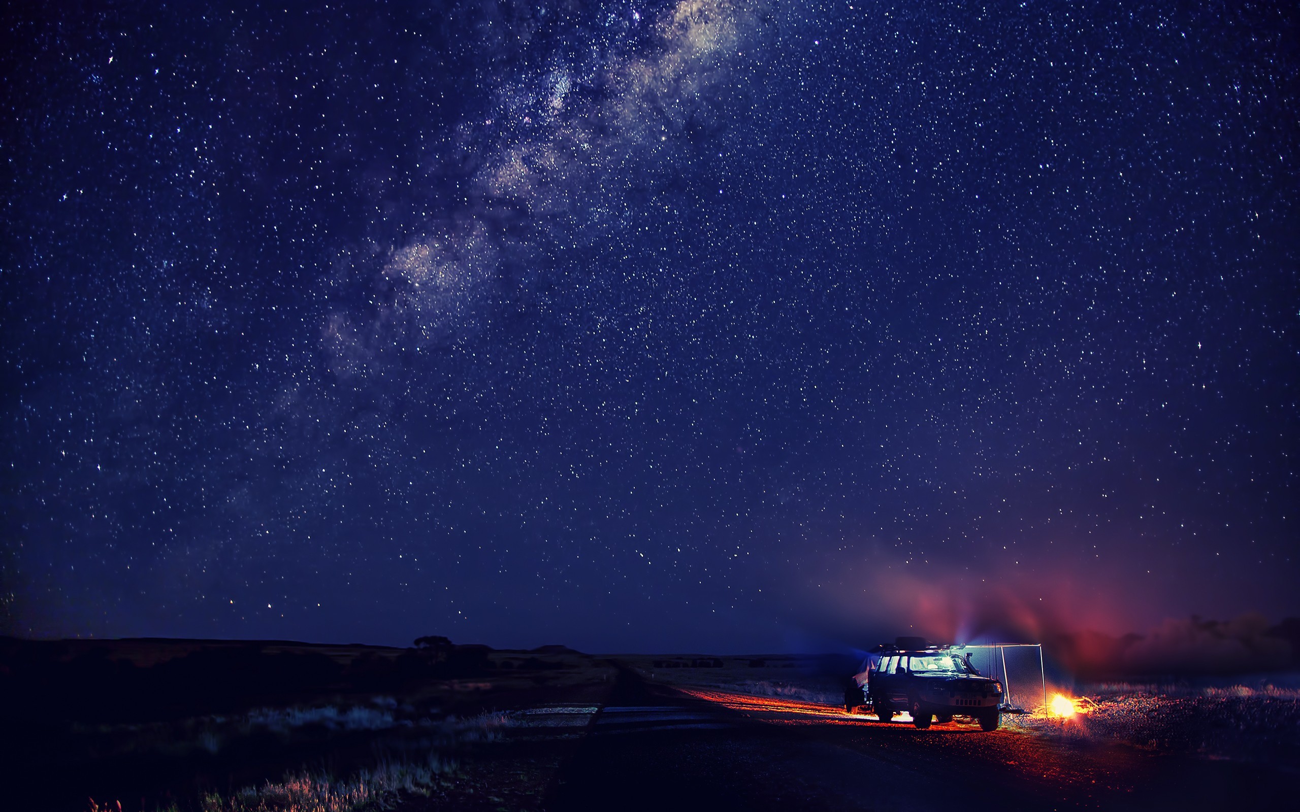 Car parked under a starry night sky HD Wallpaper