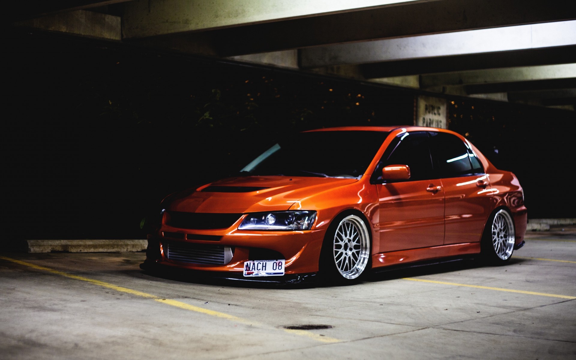 Orange Mitsubishi Lancer Evolution parked in a garage HD Wallpaper