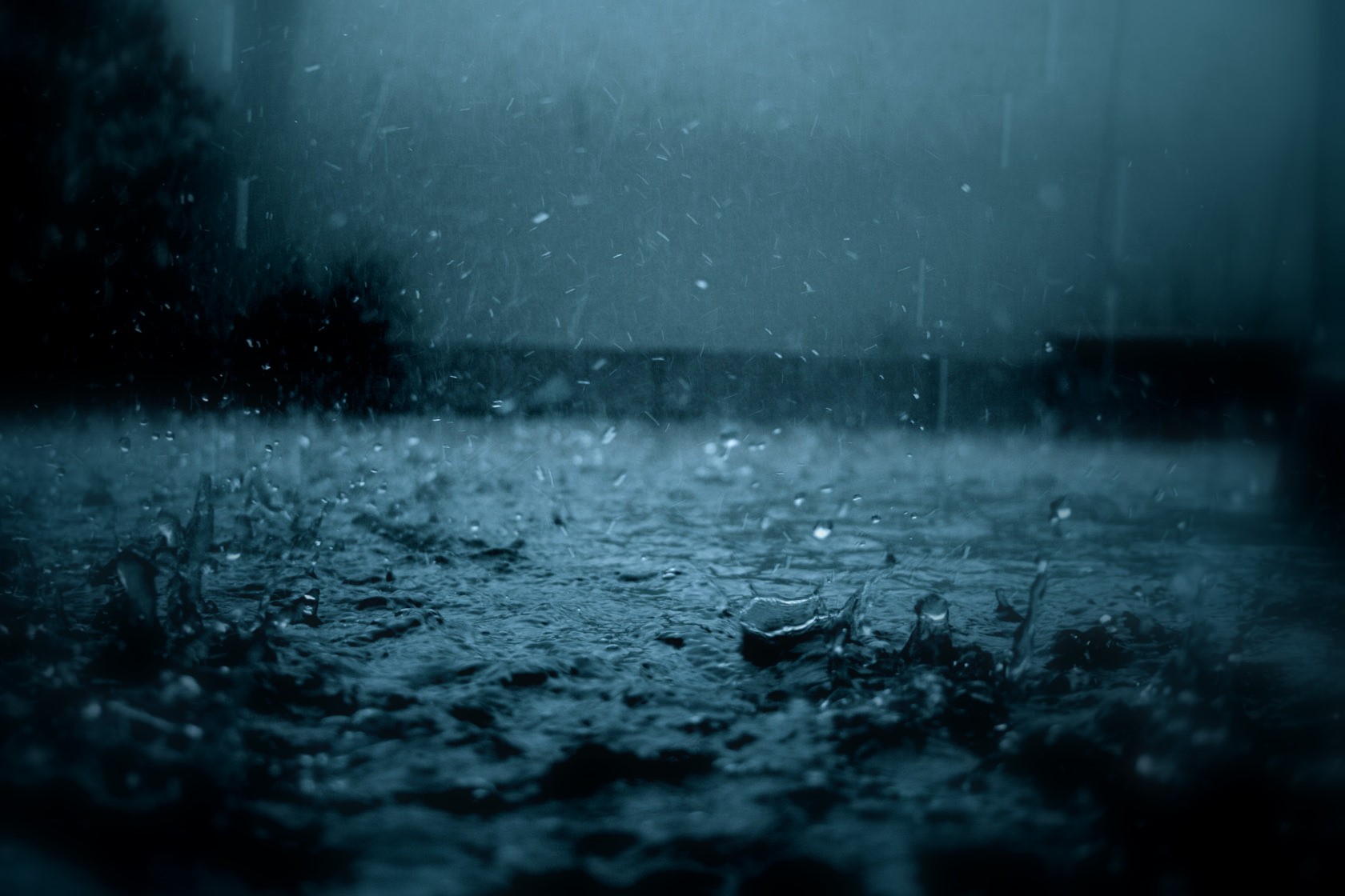 Raindrops falling on a dark, wet surface HD Wallpaper