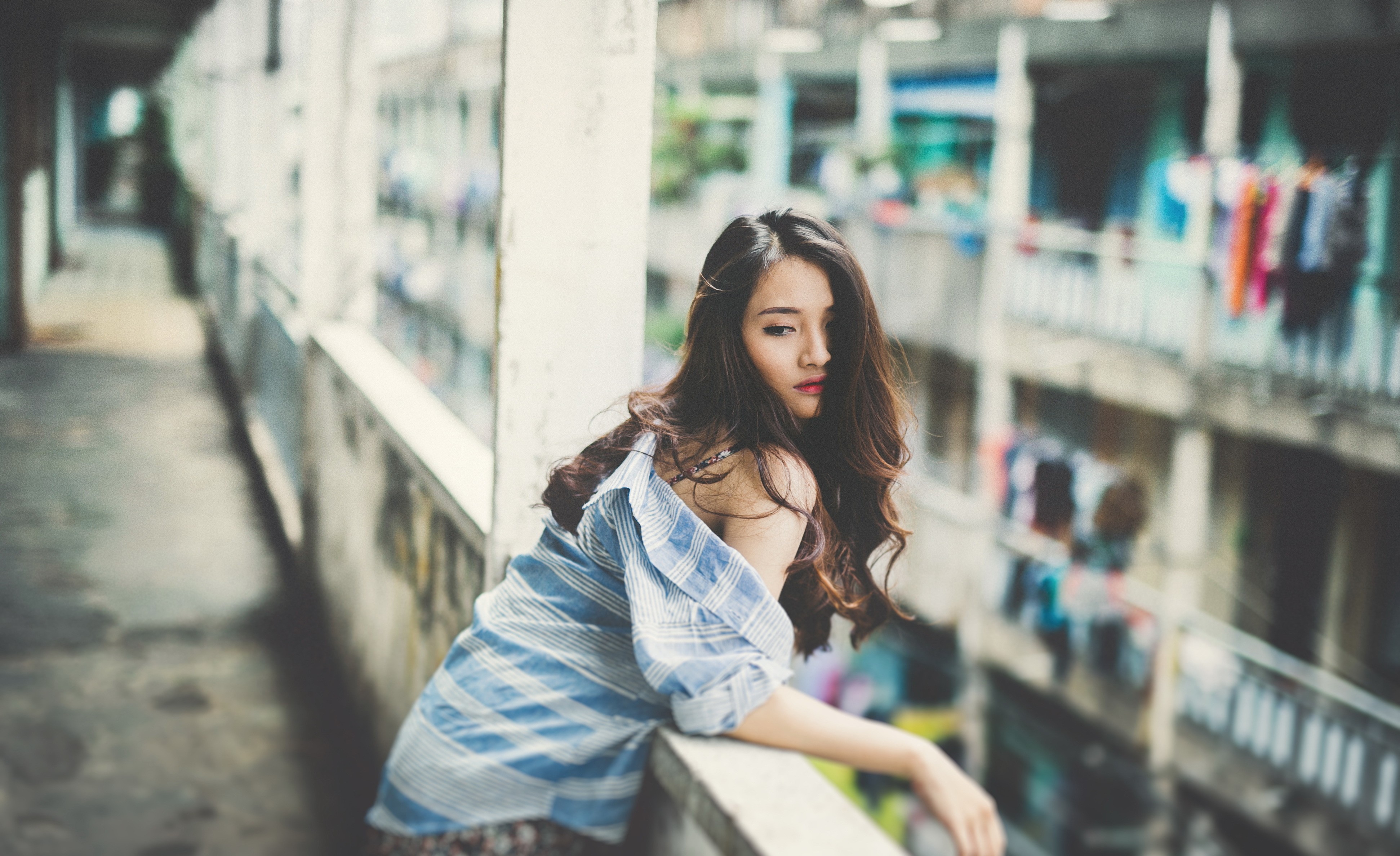 Asian woman leaning on a balcony railing HD Wallpaper