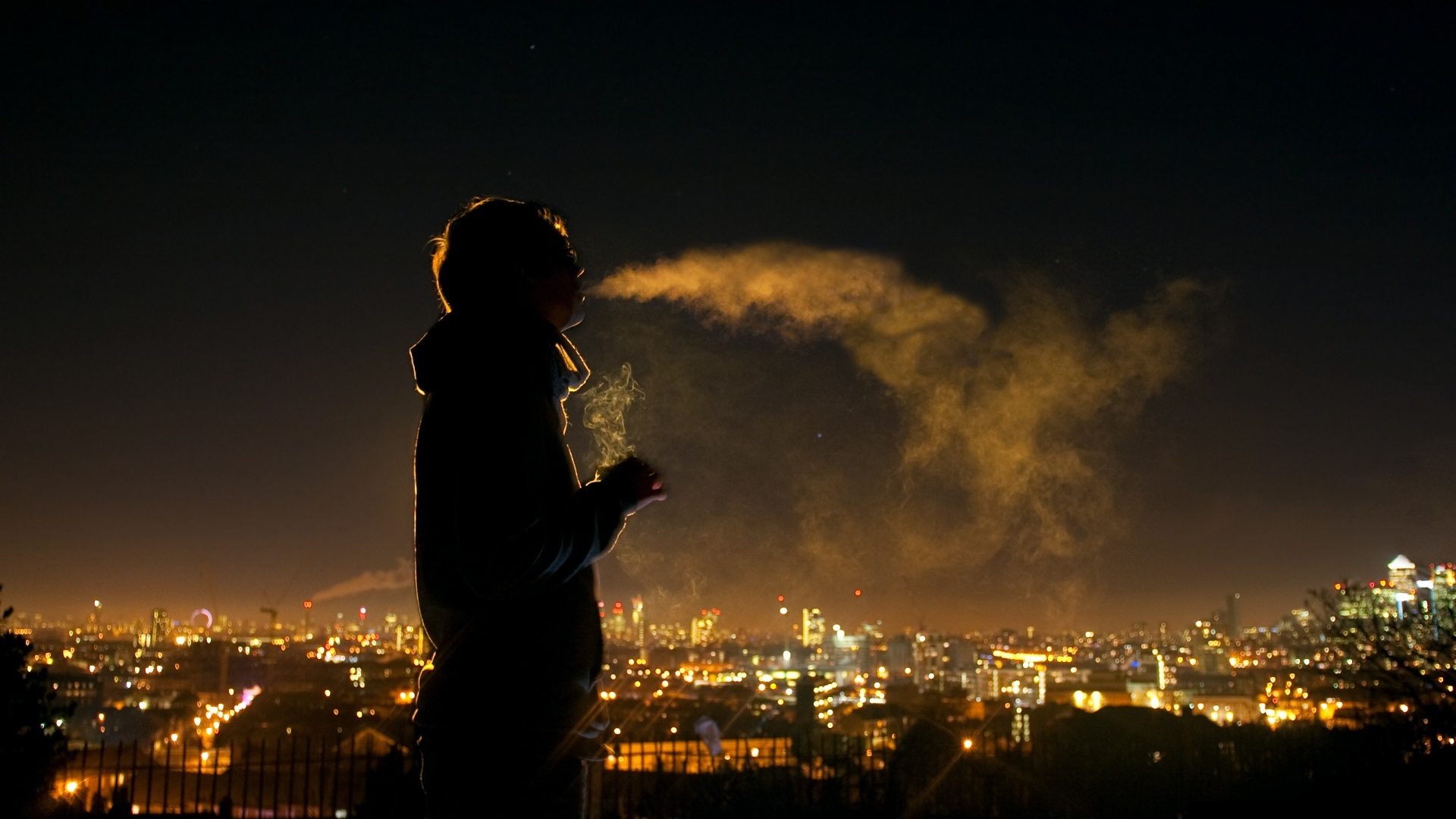 Person smoking at night overlooking city lights HD Wallpaper