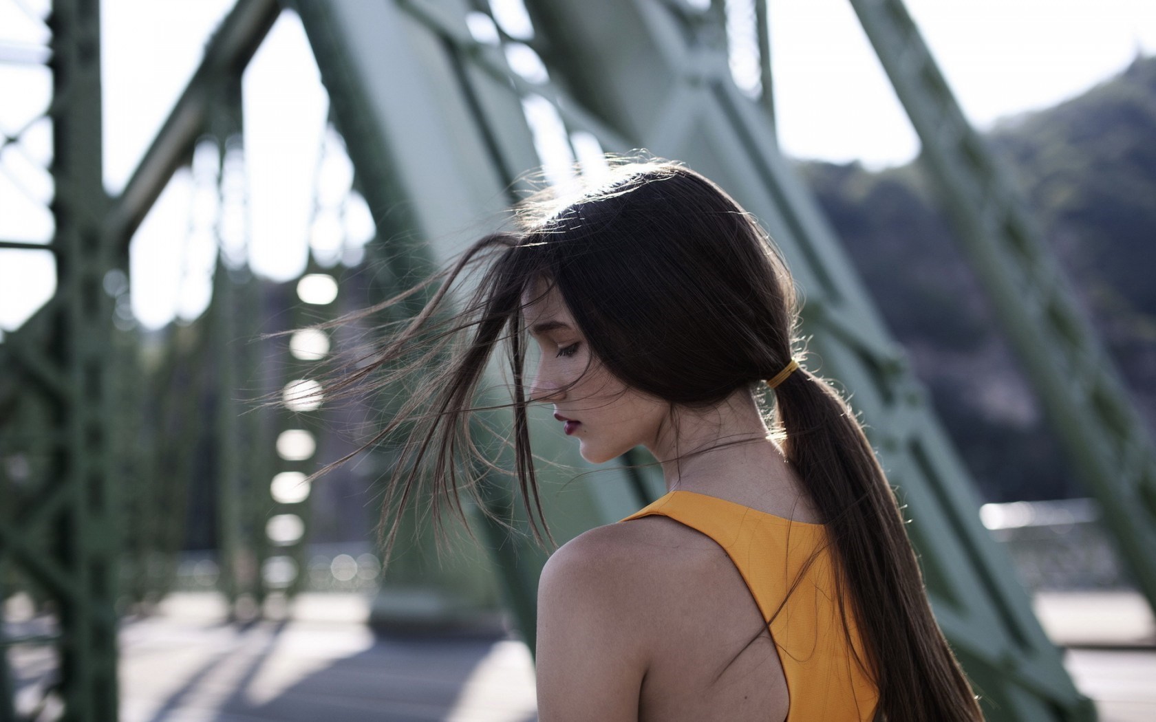Woman with long brown hair in a ponytail on a bridge HD Wallpaper