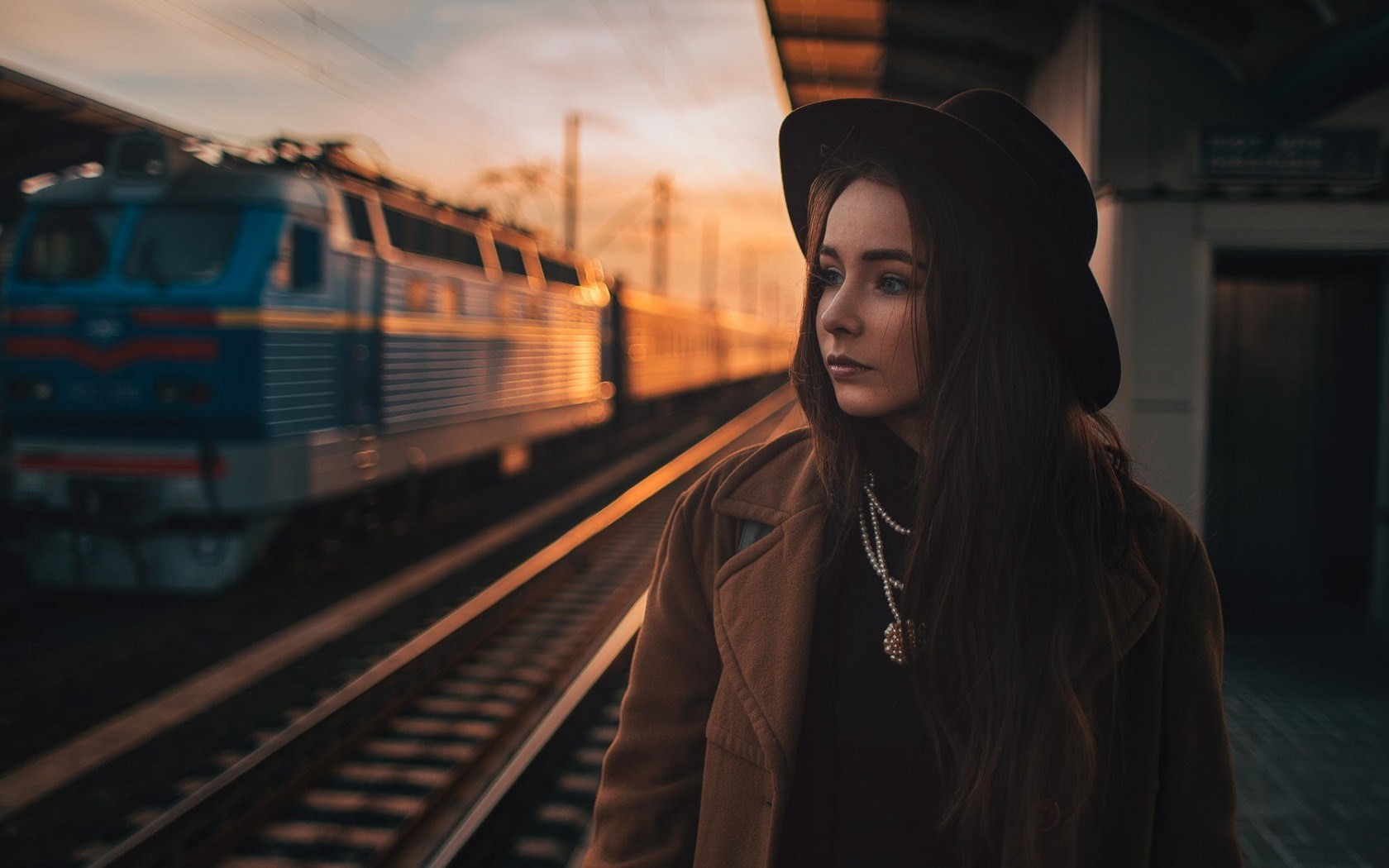 Woman in hat on train platform at sunset HD Wallpaper