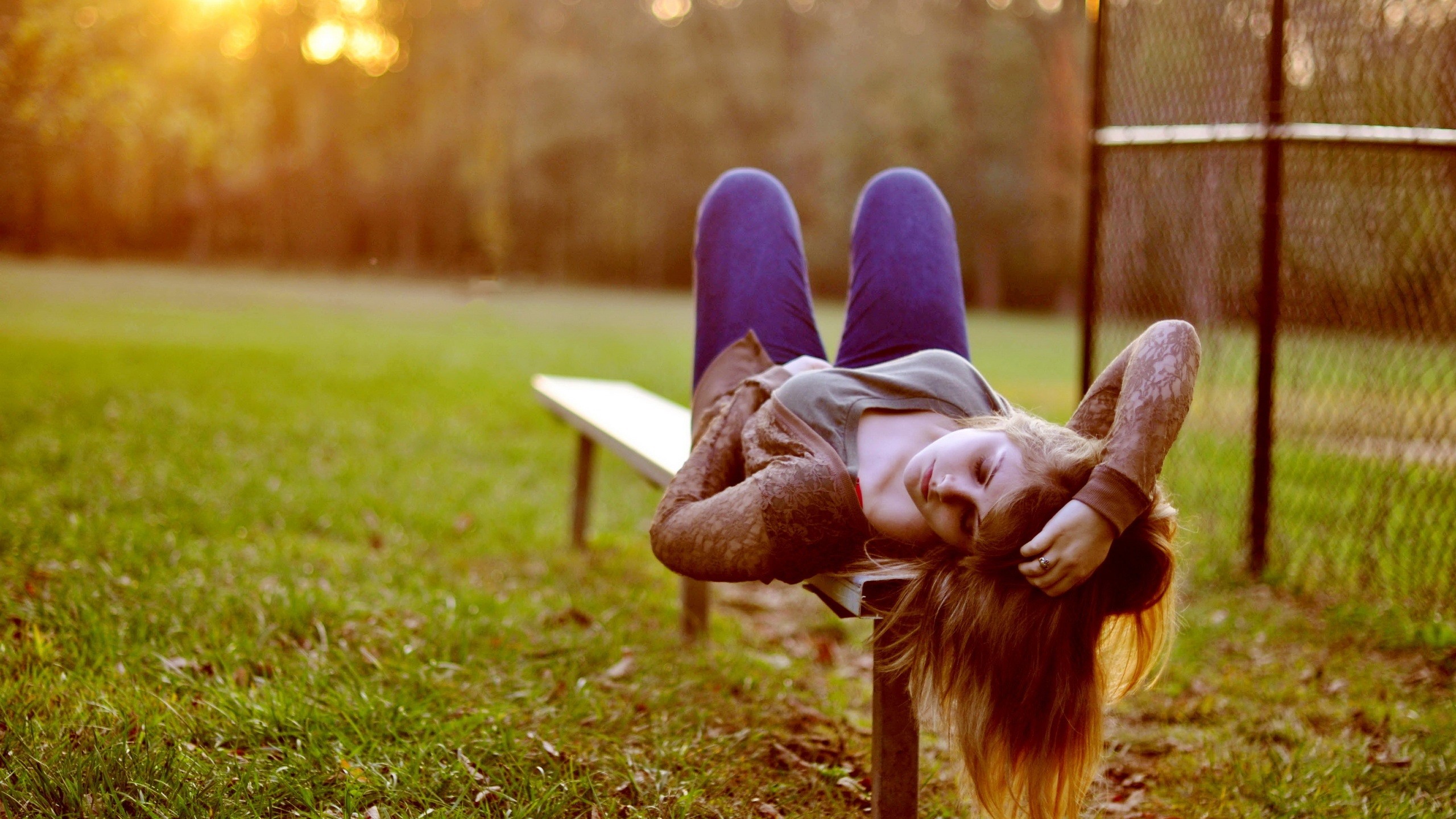 Woman lying on a bench outdoors HD Wallpaper
