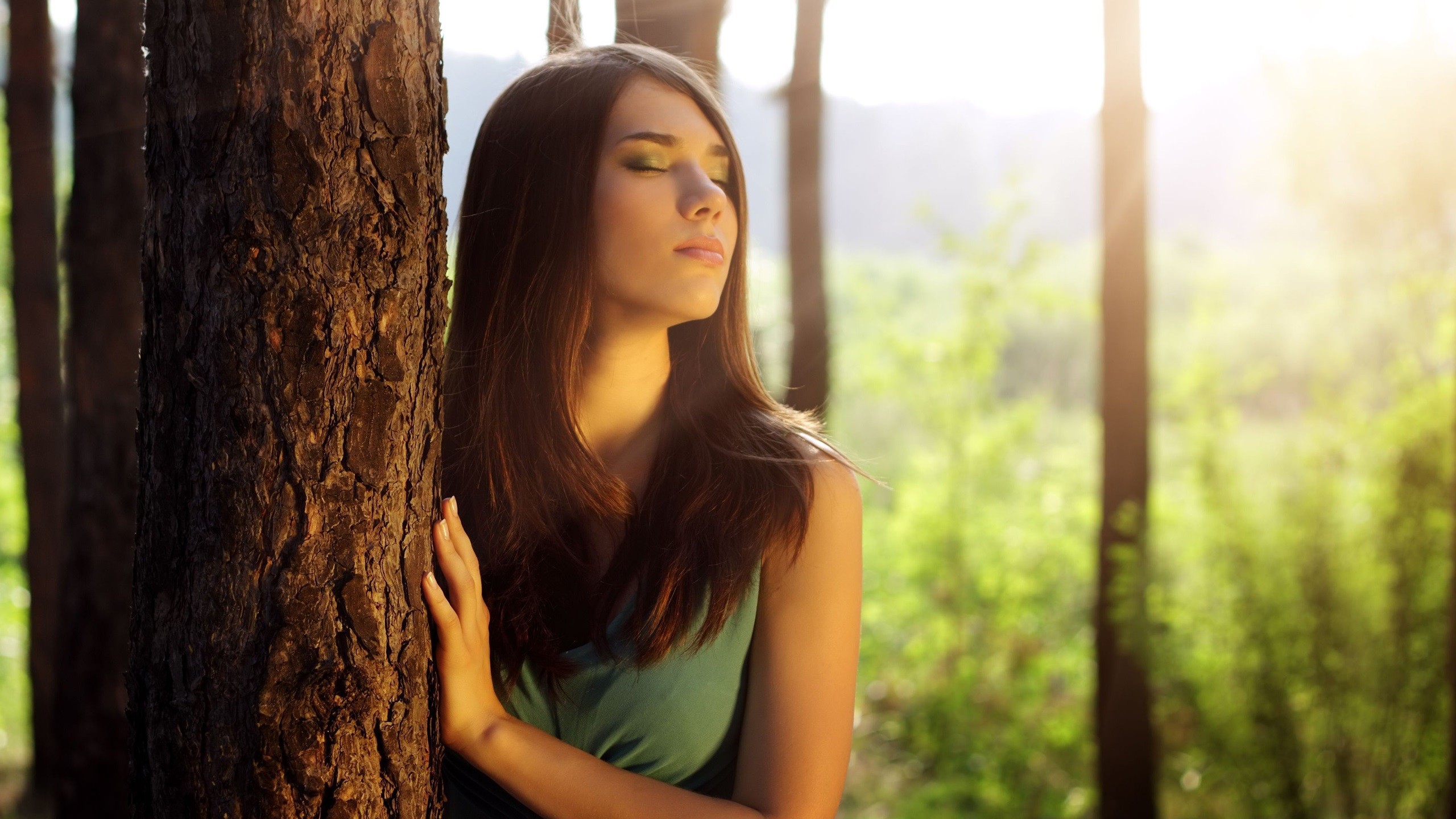 Woman with closed eyes leaning against a tree HD Wallpaper