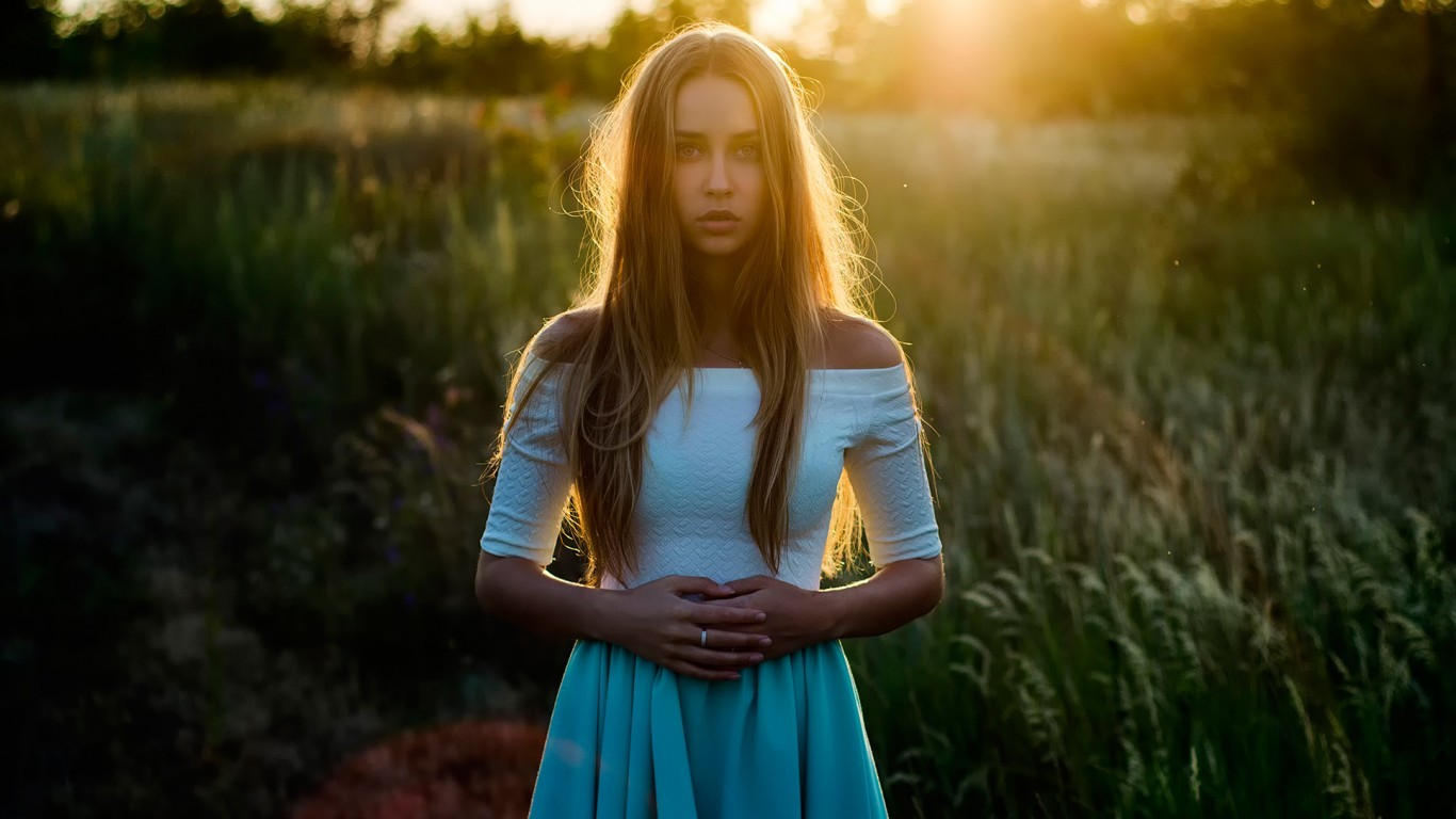 Woman in a white top and skirt in a field at sunset HD Wallpaper