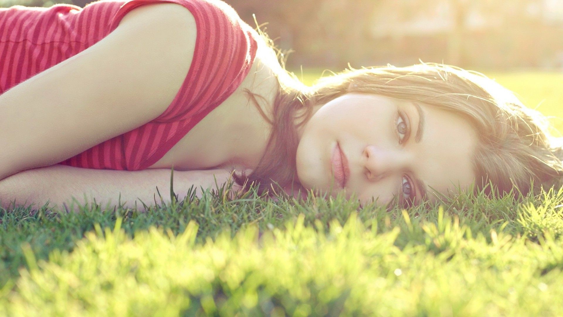 Woman lying in grass in sunlight HD Wallpaper