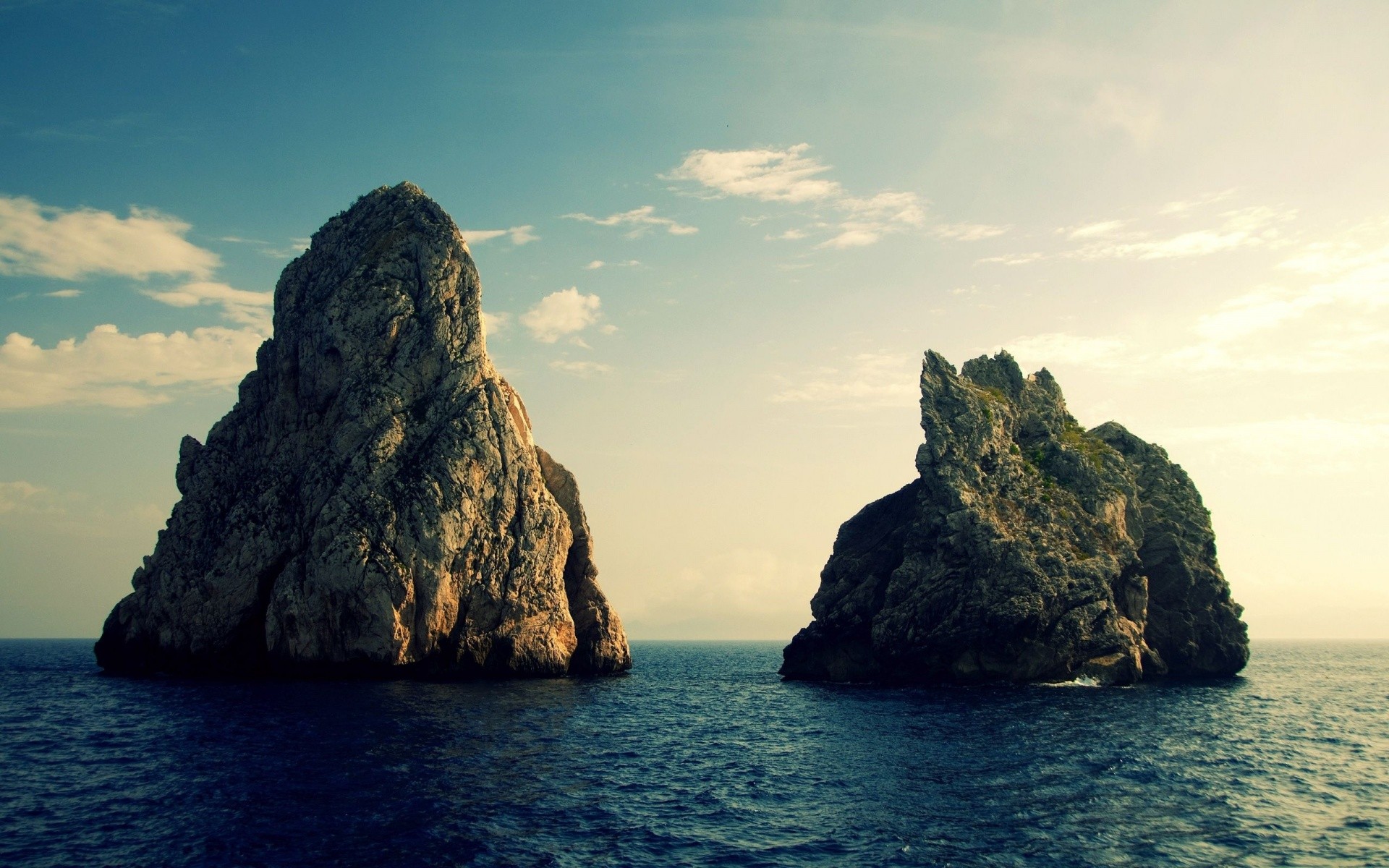 Two rocky islands in the sea under a cloudy sky HD Wallpaper