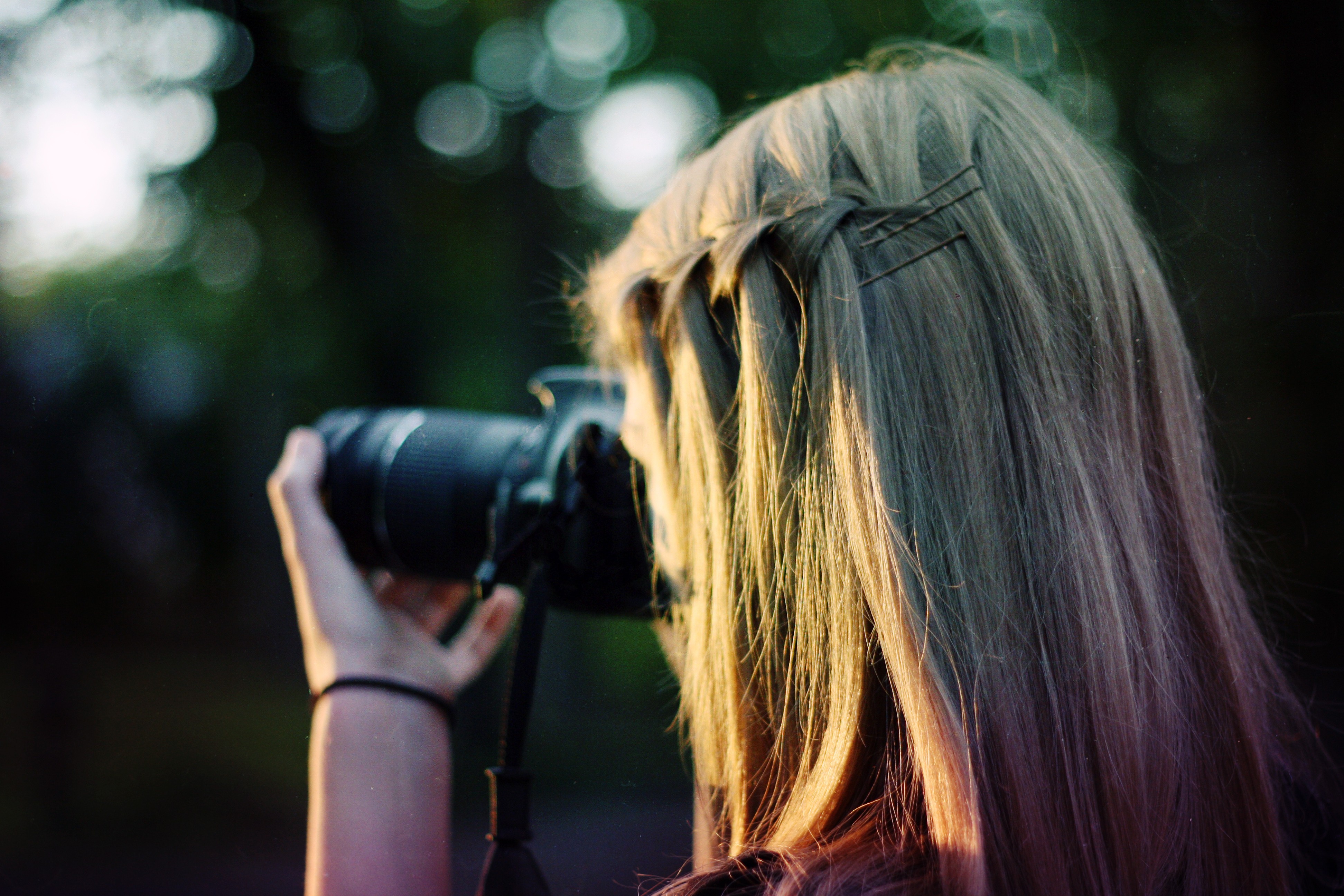 Woman with blonde hair taking a photo with a camera HD Wallpaper
