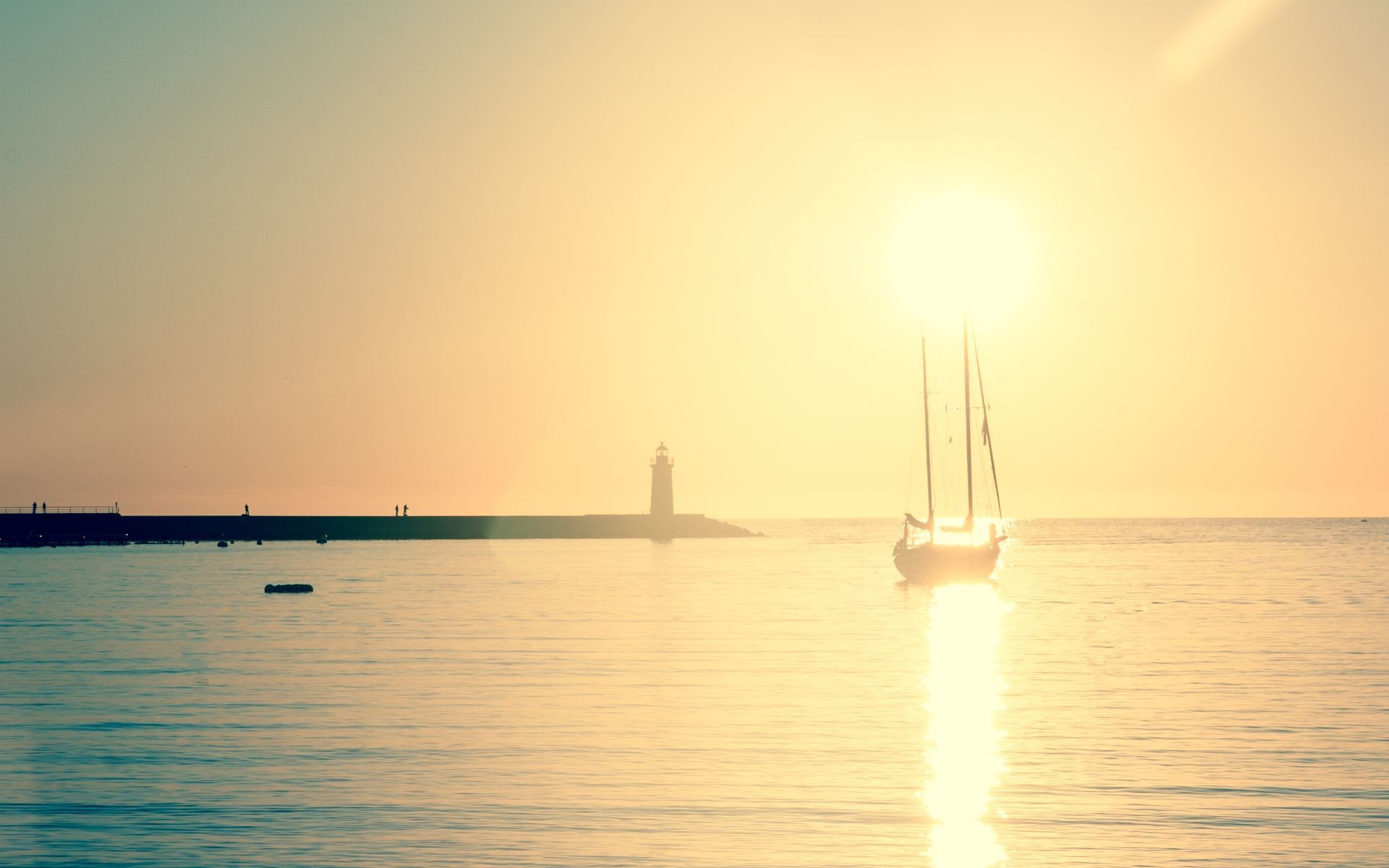 Sailboat and lighthouse at sunset over the sea HD Wallpaper