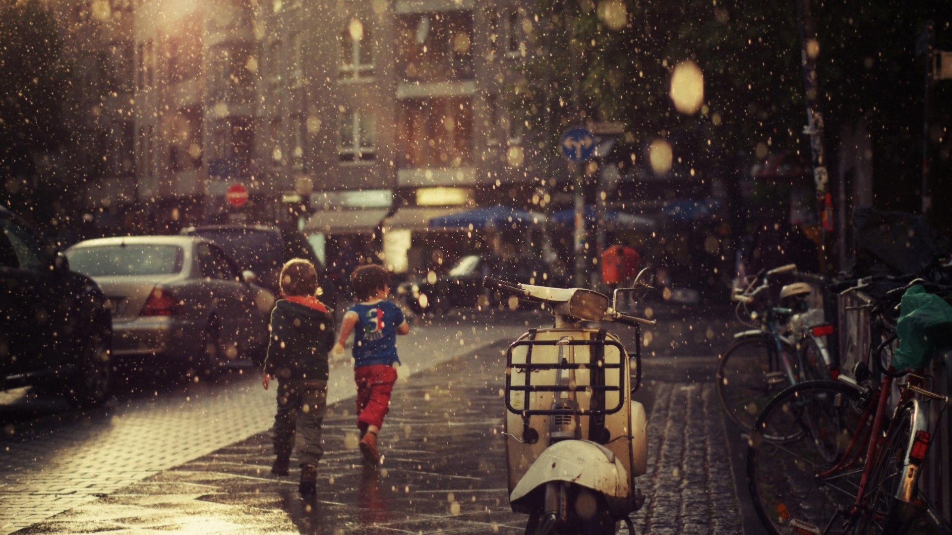 Two children run in the rain on a city street HD Wallpaper