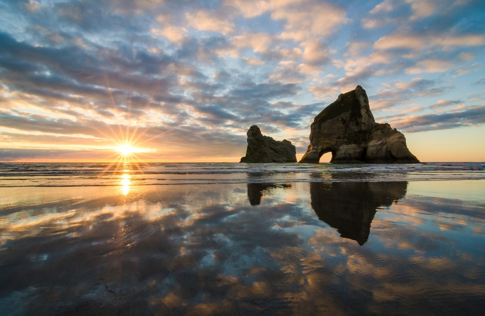 Sunset over Wharariki Beach with rock formations HD Wallpaper