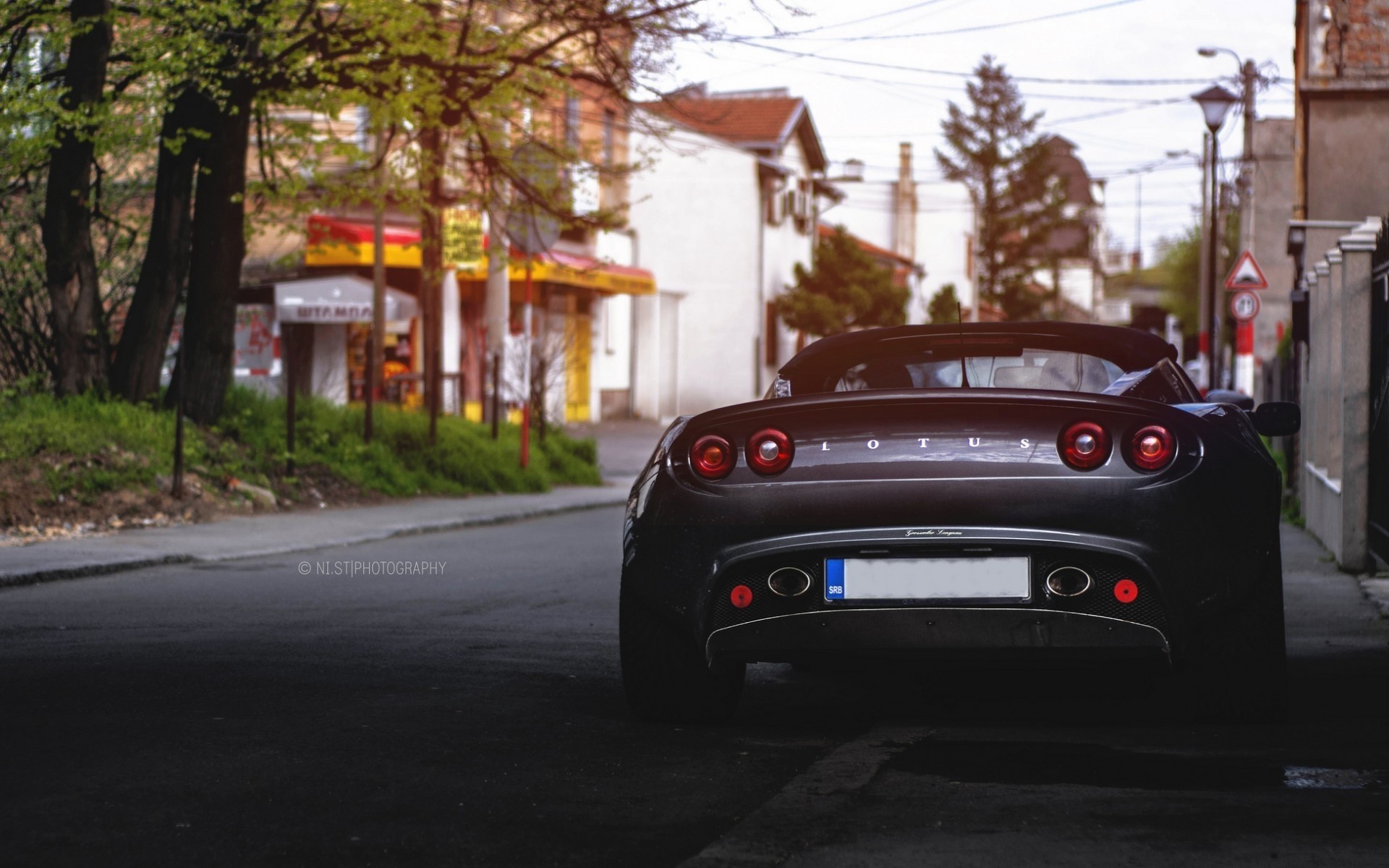 Dark Lotus car parked on a street HD Wallpaper