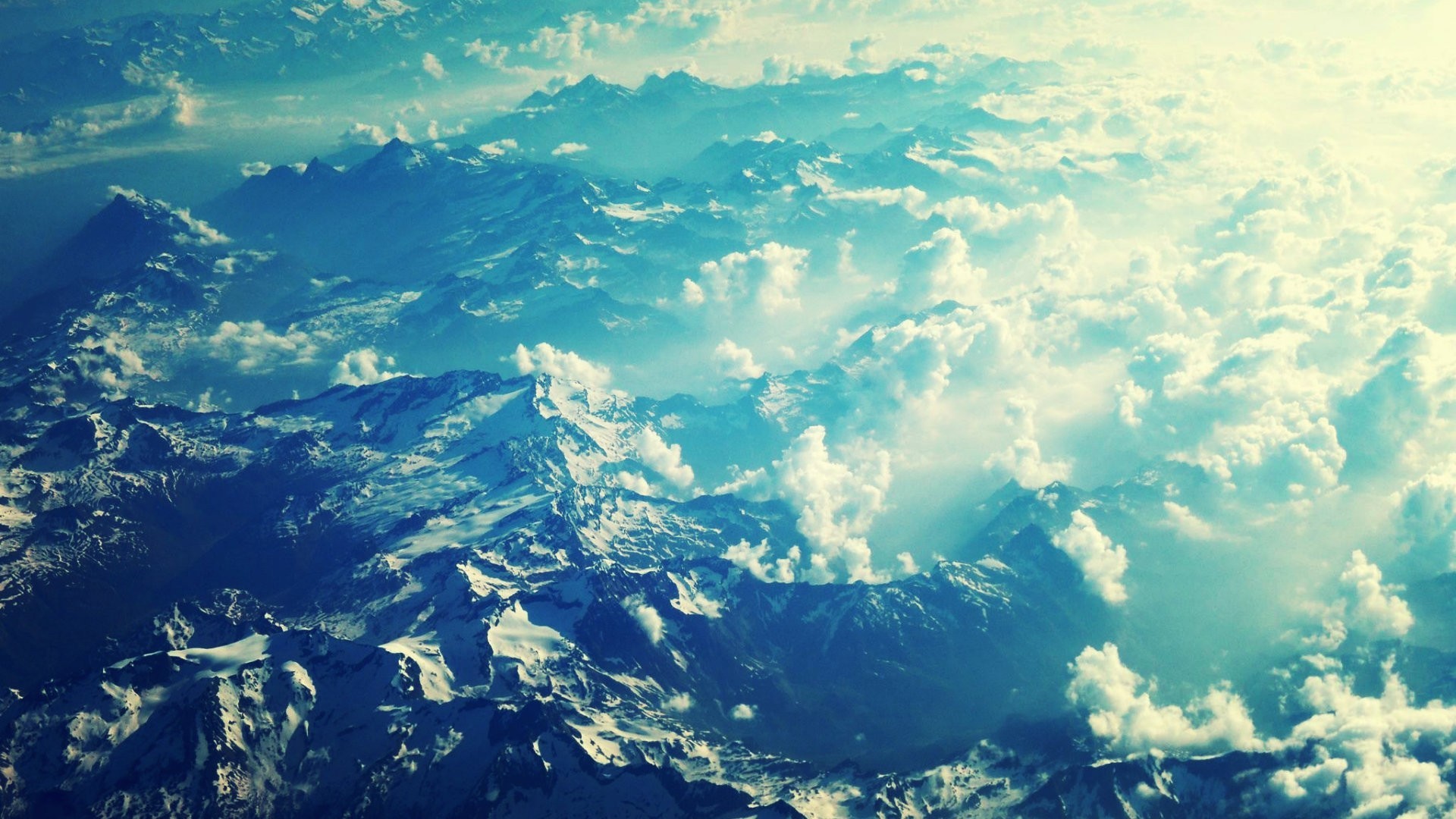 Aerial view of snow-capped mountains and clouds HD Wallpaper