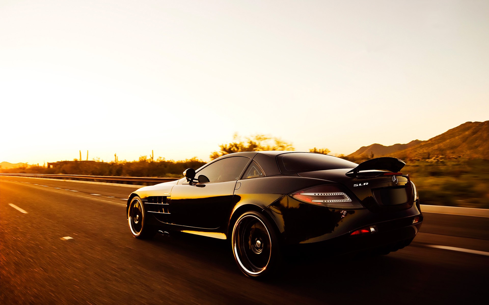 Black Mercedes-Benz SLR driving on a desert highway at sunset HD Wallpaper