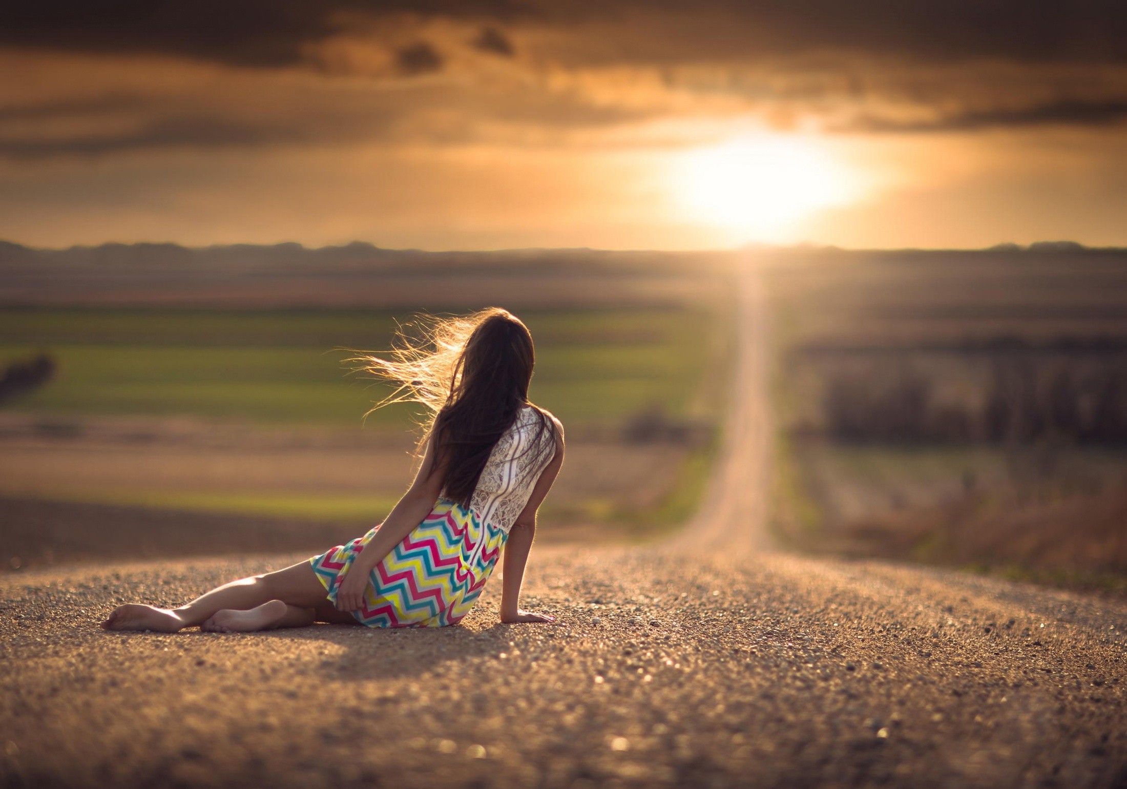 Woman sitting on a road at sunset in Nebraska HD Wallpaper