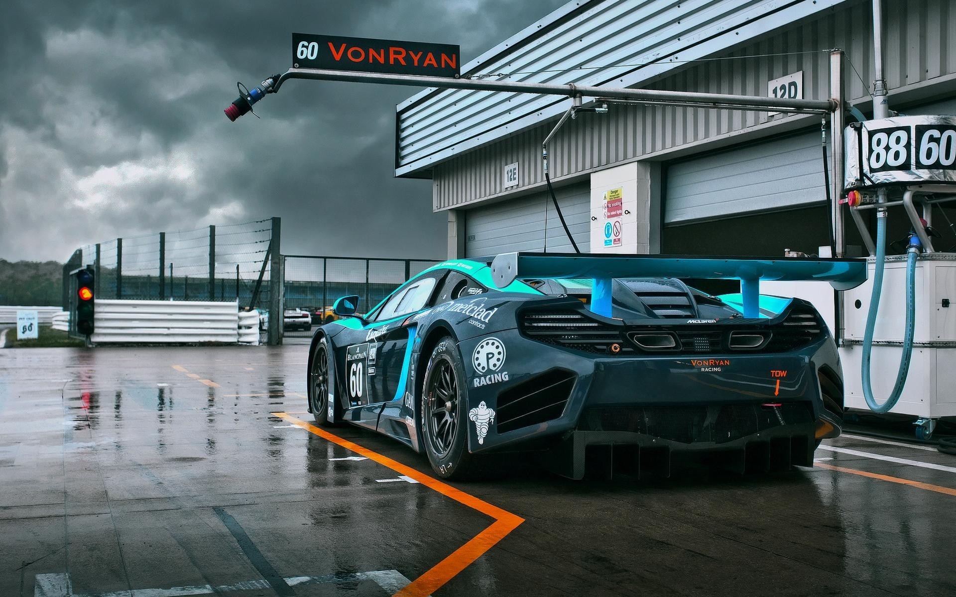 McLaren race car with number 60 on a wet track HD Wallpaper