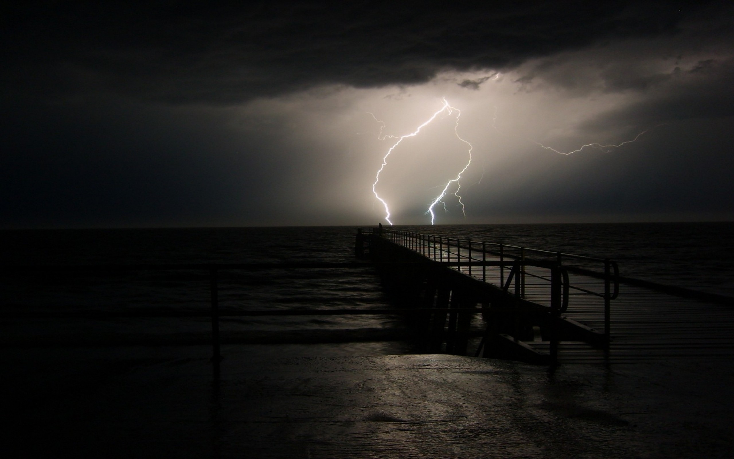 Lightning strikes over a pier during a storm HD Wallpaper