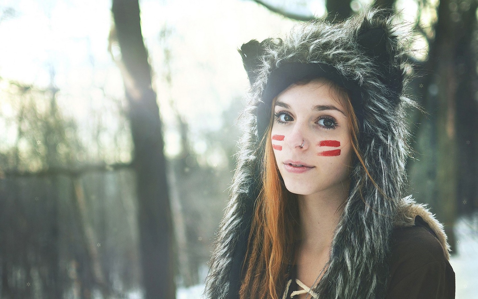 Woman with face paint and fur hood in forest HD Wallpaper