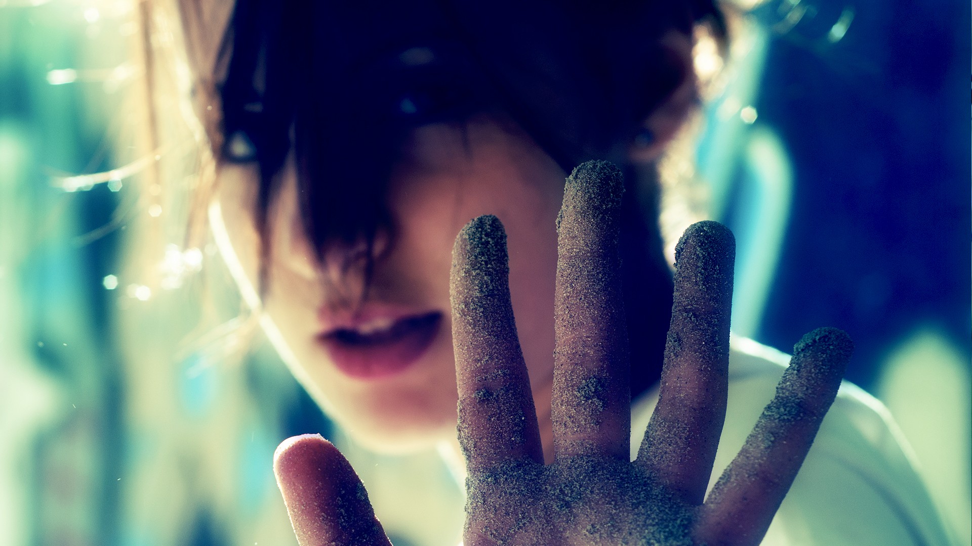 Woman with sand-covered hands reaching out HD Wallpaper