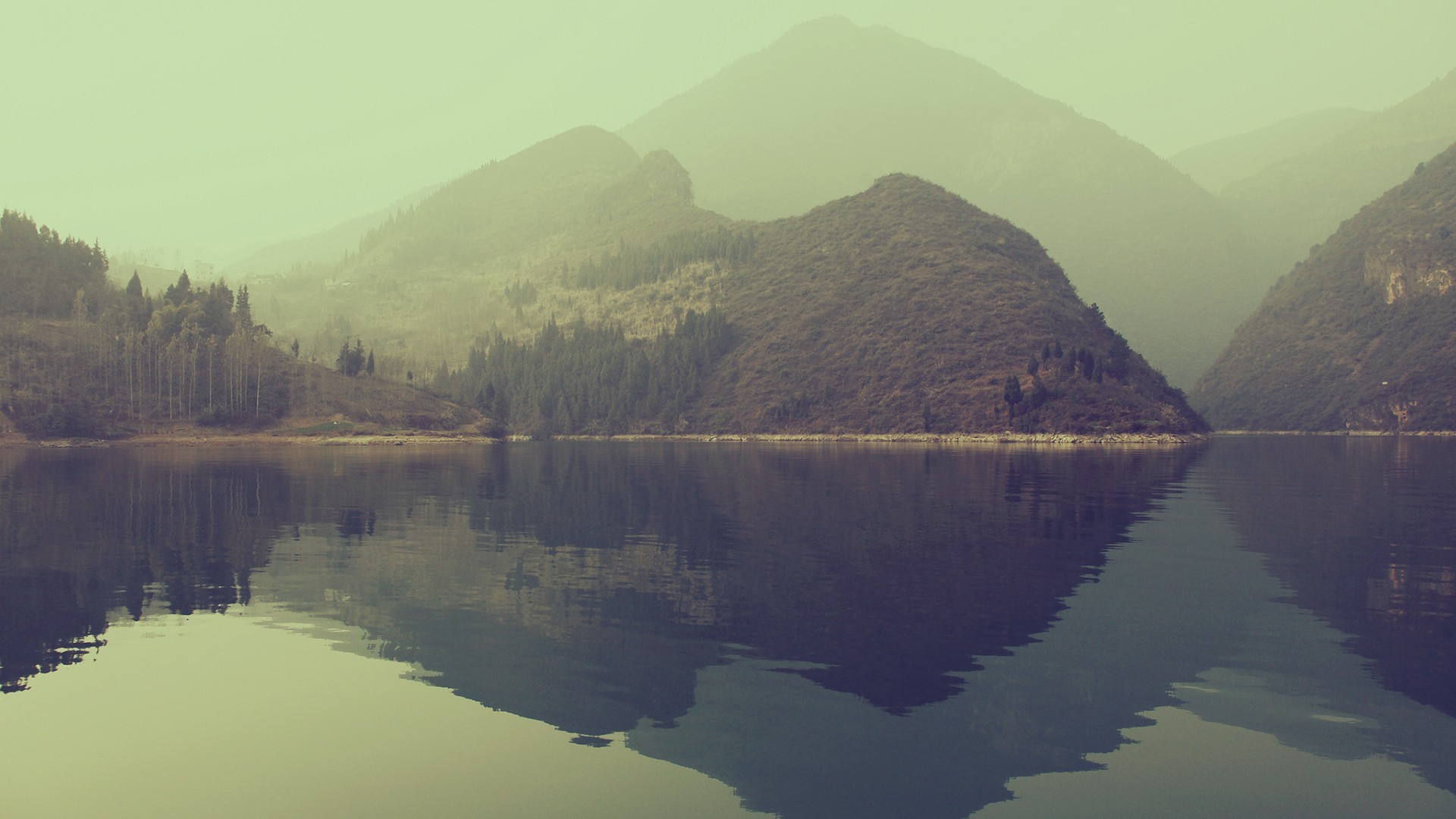 Misty mountains reflected in a calm lake HD Wallpaper