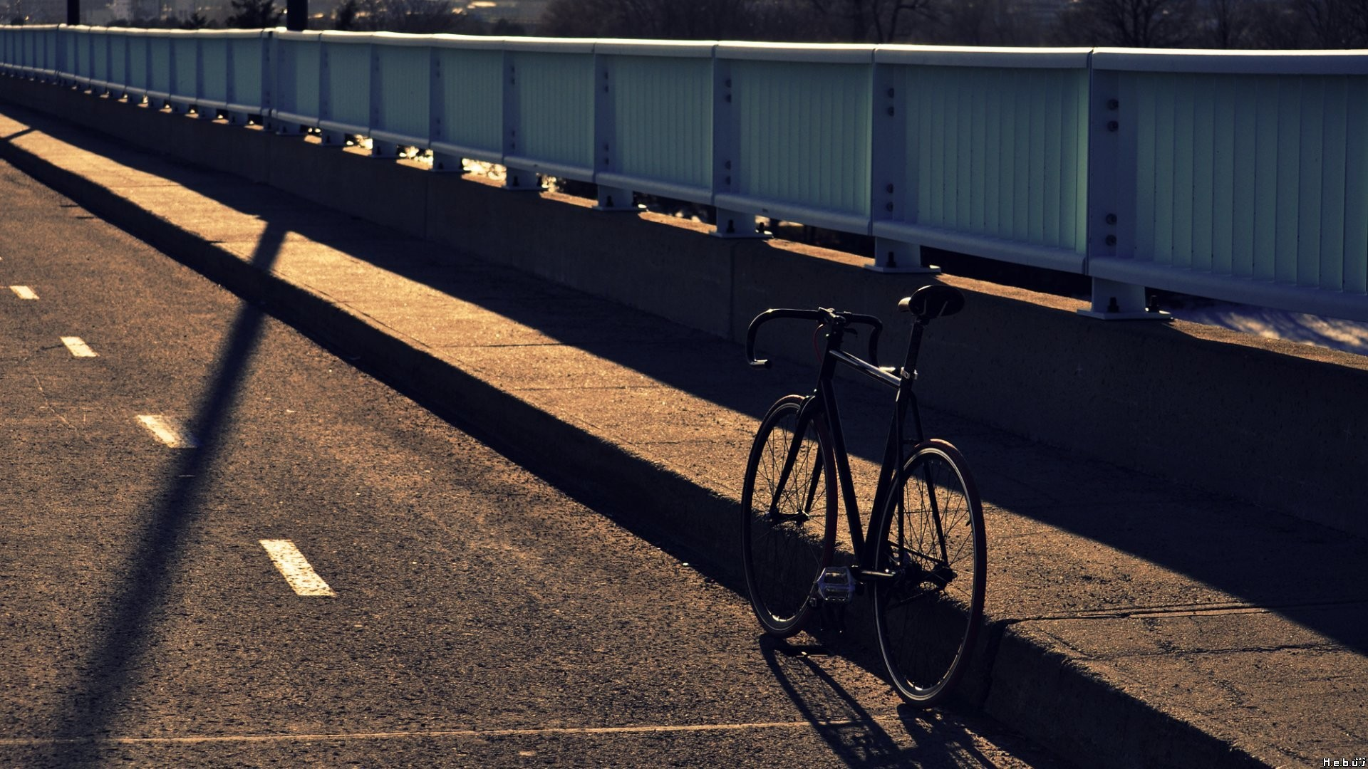 Bicycle on a bridge with long shadows HD Wallpaper