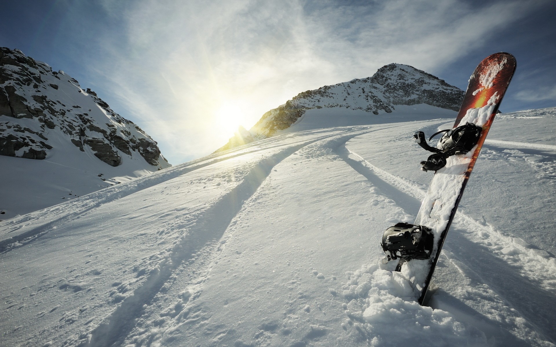 Snowboard stuck in snow on a mountain slope HD Wallpaper