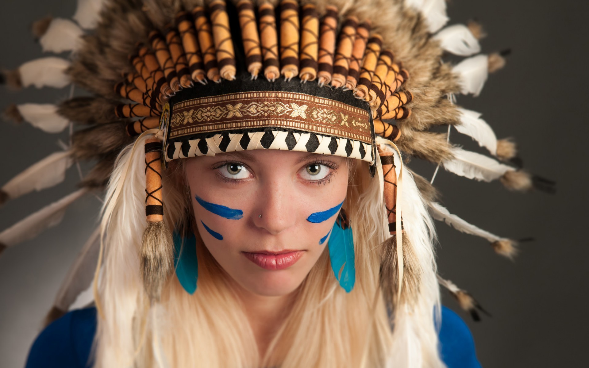Woman wearing a Native American headdress with face paint HD Wallpaper