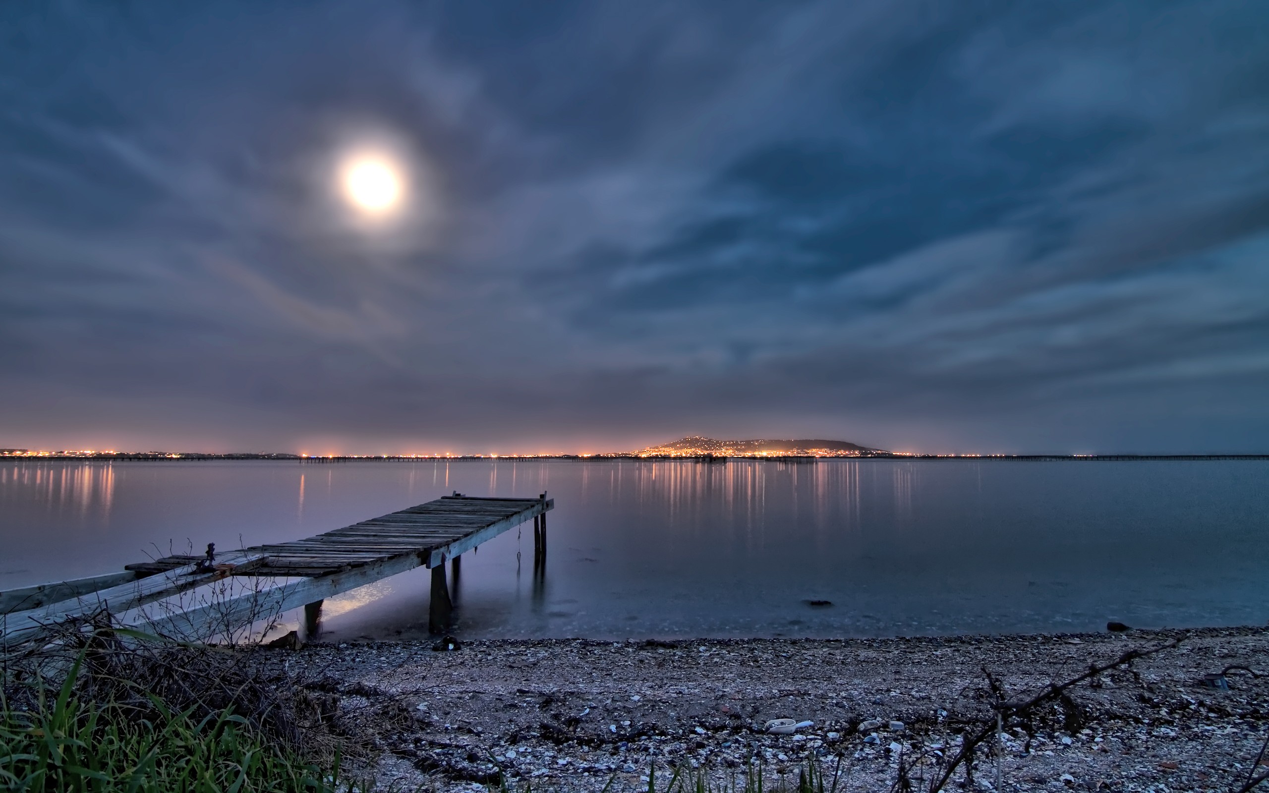 Wooden pier on a lake at night with city lights HD Wallpaper
