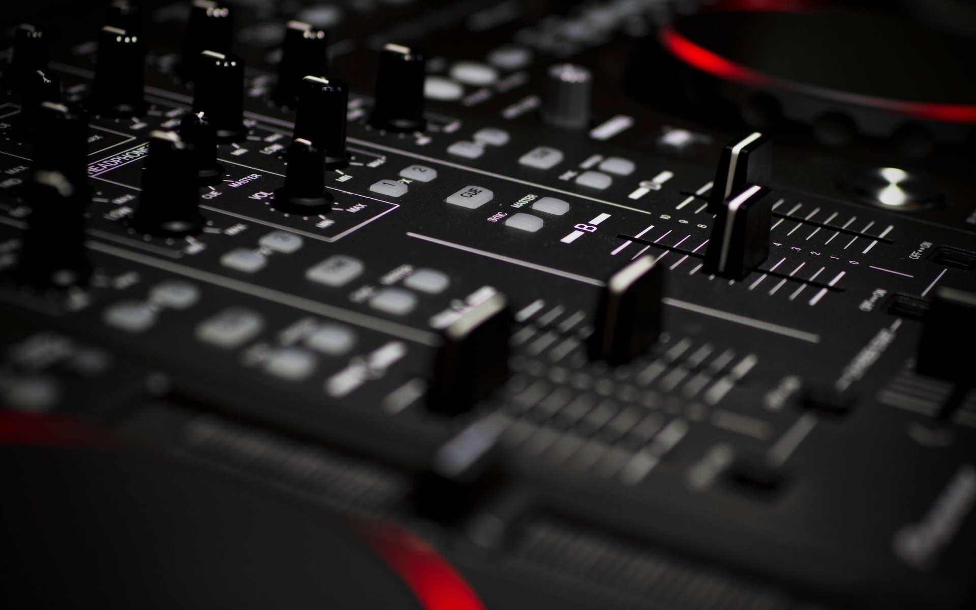 Close-up of a black DJ mixing console with red accents HD Wallpaper