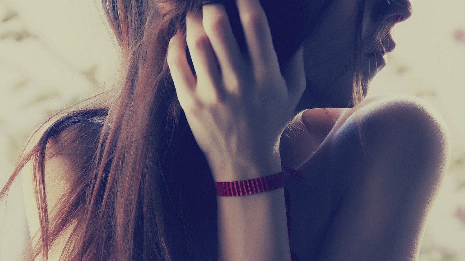Woman with long brown hair holding a phone to her ear HD Wallpaper