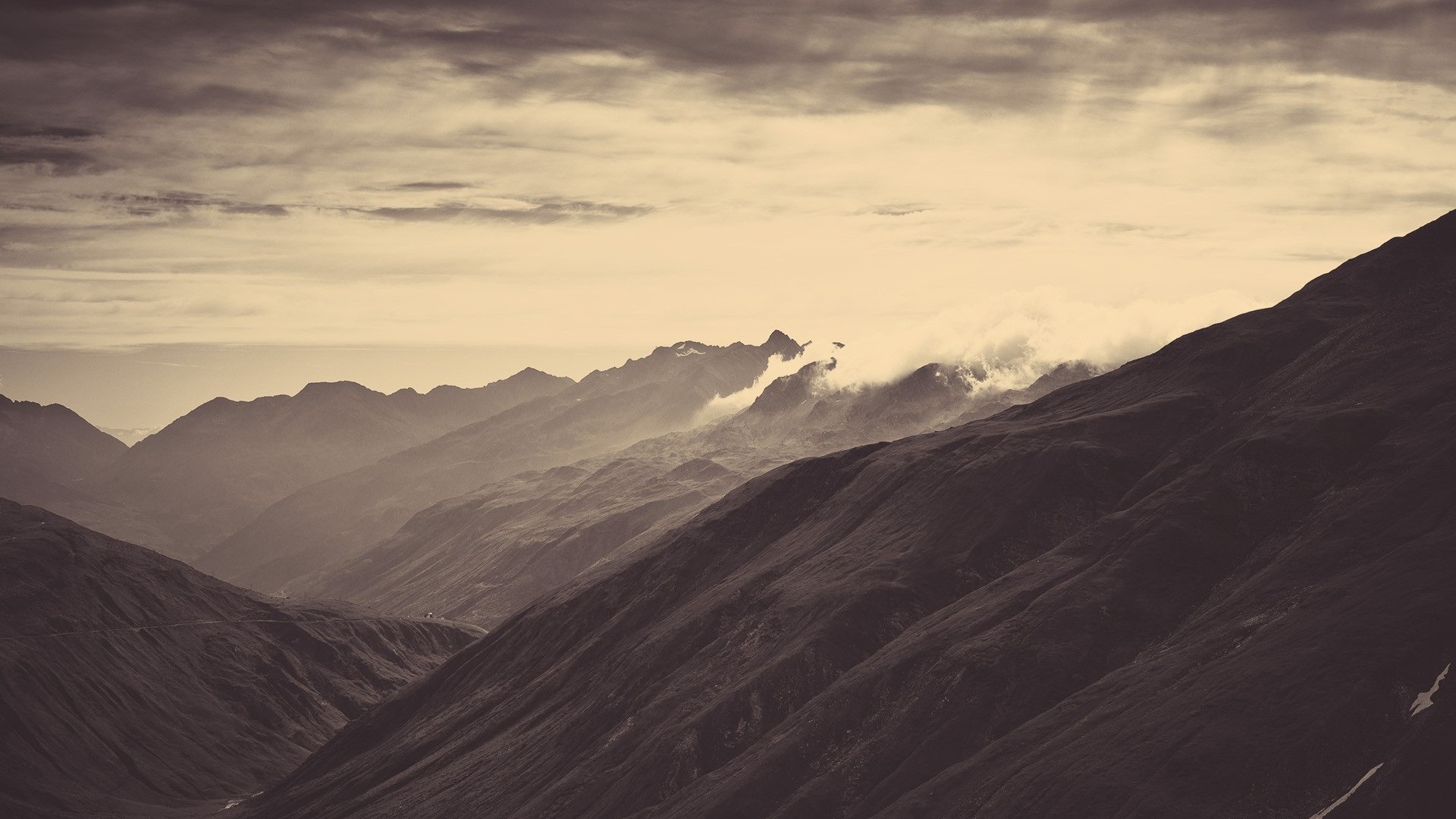 Dark mountains under a cloudy sky HD Wallpaper
