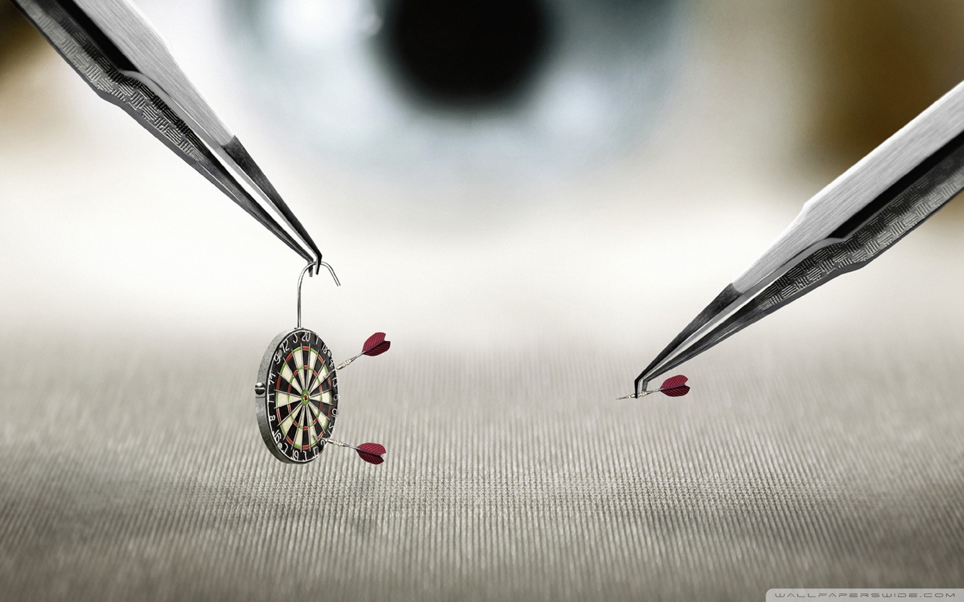 Miniature darts and tweezers with eye in background HD Wallpaper
