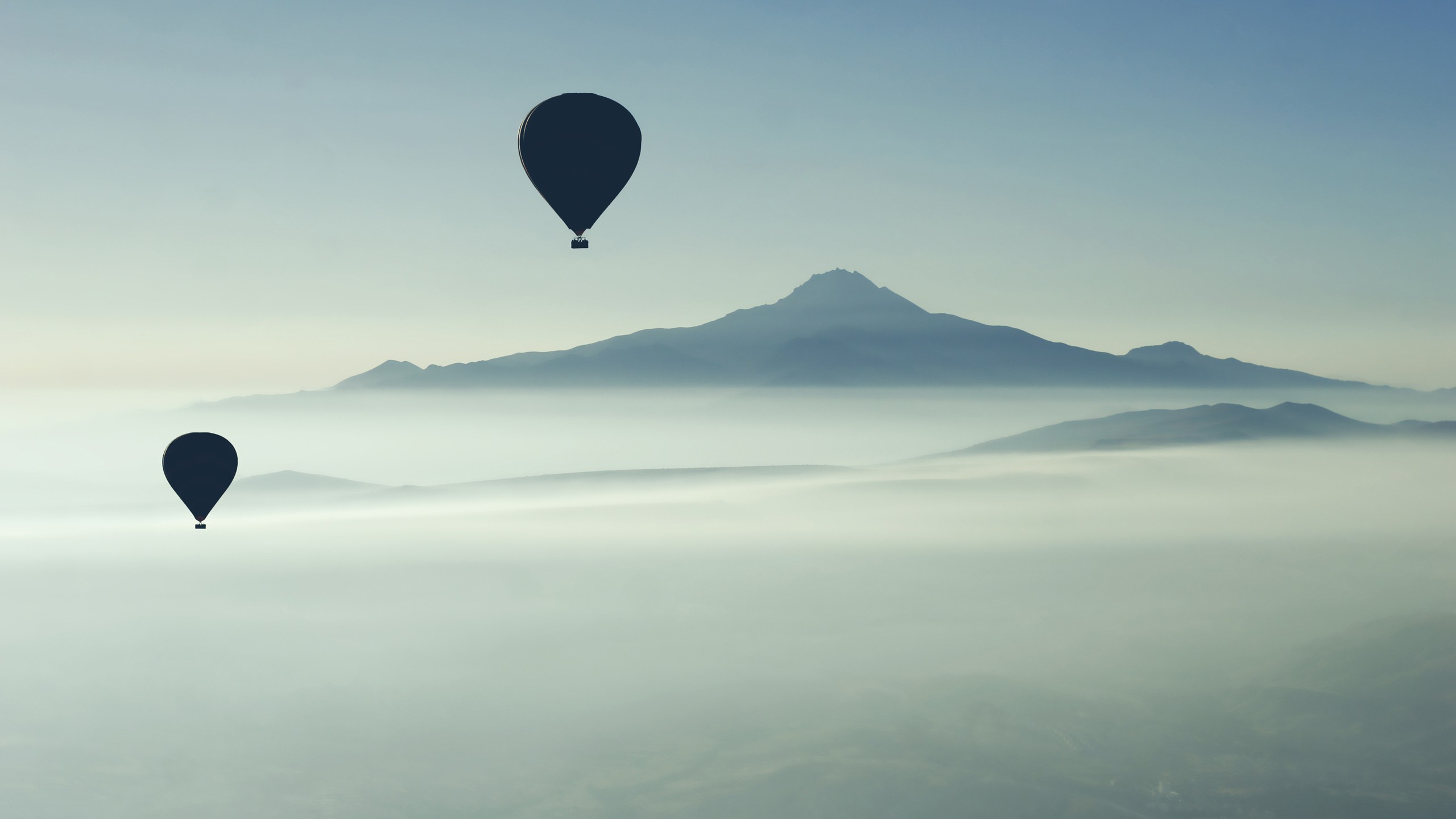Hot air balloons over misty mountains HD Wallpaper
