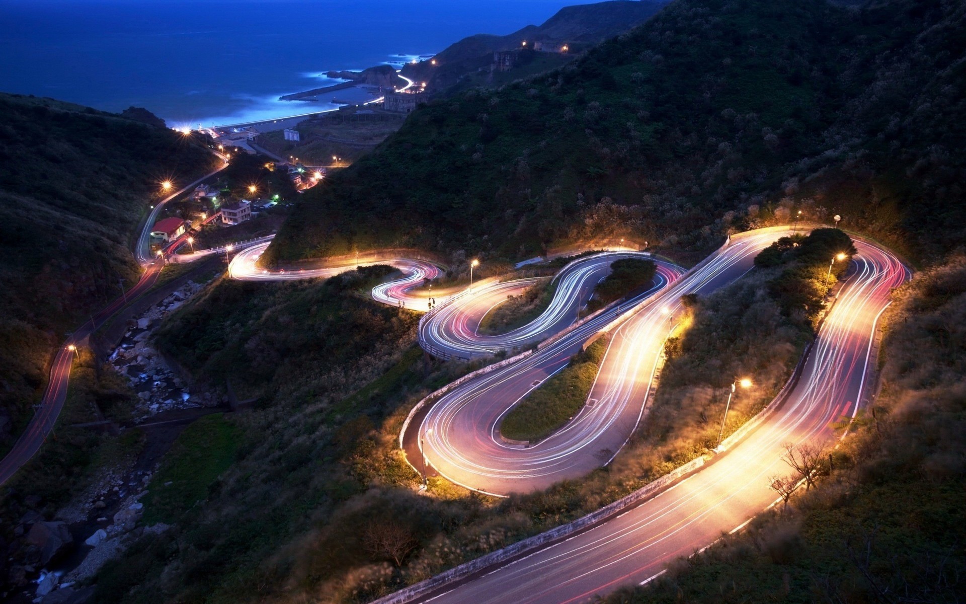 Long exposure of a winding mountain road at night HD Wallpaper